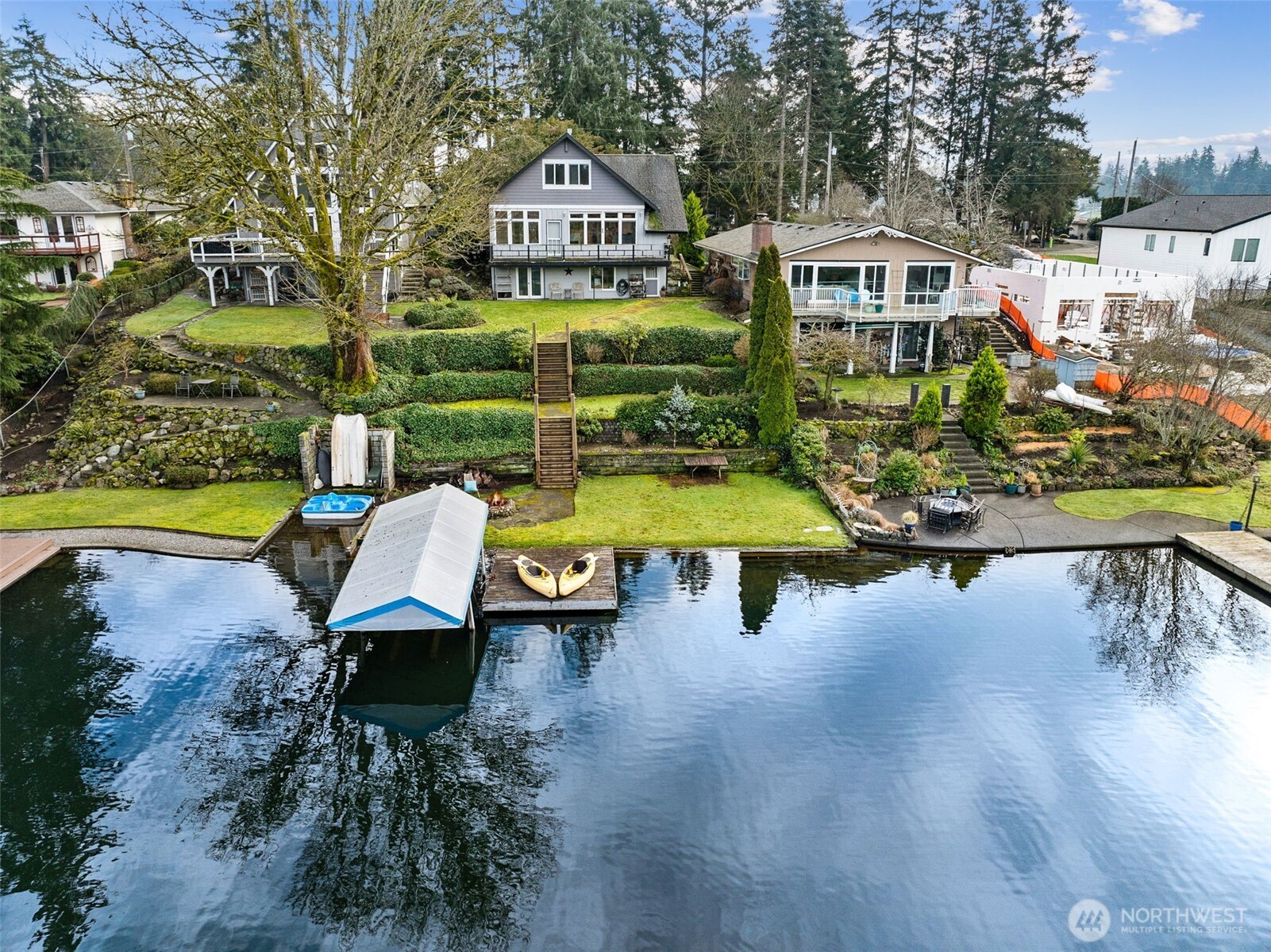 Rare opportunity on Enchanted Island at Spanaway Lake, first time on the market! Travel over an idyllic 1 lane bridge and arrive at the island - 26 homes nestled in a park like setting, large maintained greenbelt & sports court at the center encircled with parking & lighting. Beautiful landscaping tucks this home into its own tranquil world, including 50 ft of lake frontage offering a PRIME spot on the lake, a quiet corner basking in sunshine all summer long. Enjoy your terraced landscaped backyard with personal dock. This home has been lovingly maintained and is ready for your vision! Main floor features 2 bedrooms, 1 bath and outstanding lake views! 2nd floor is approximately 600 sq/ft semi-finished, ready for a custom primary with en suite. Daylight basement is a studio apartment complete with full kitchen, bath and laundry - separately metered. Peaceful, fully fenced & usable front yard with mature landscaping. Hardwoods under carpet, attached 1 car garage, vaulted ceilings, there's too much to list! Opportunities on enchanted island are few and far between, act now!