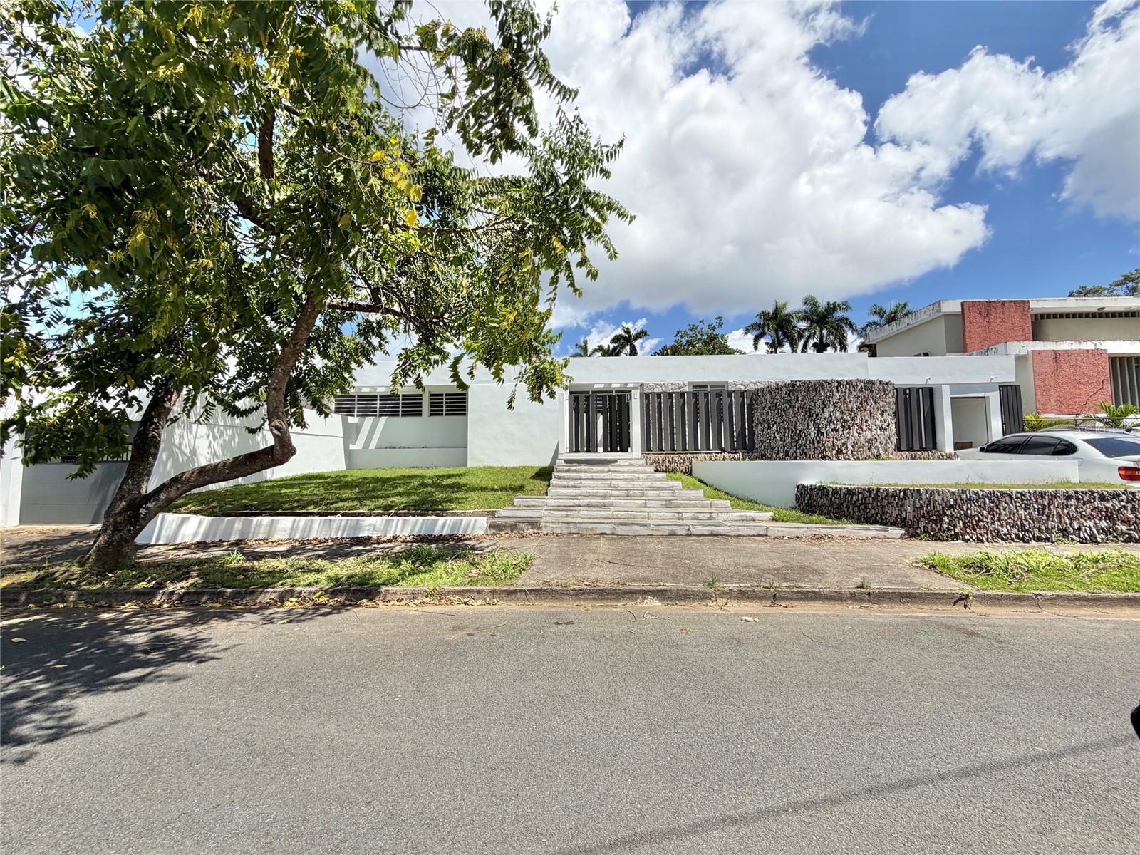Spacious and elegant one-level residence located Urb. San Francisco-San Juan, offering approximately 5,082 square feet of living area on an expansive 1,546 square meter lot. This property stands out for its open-concept design, high ceilings, and abundant natural light, creating a warm and functional environment ideal for both family living and entertaining. It features six bedrooms and five and a half bathrooms, along with high-quality finishes including granite and wood flooring, a solid wood kitchen with stainless steel appliances, and cedar-lined closets en every bedroom. Outdoors, the home embraces the Caribbean lifestyle with a private swimming pool, a large terrace, an expansive patio, and a half basketball court, perfect for recreation and gatherings. Additional features include air conditioning, a cistern, and parking capacity for three vehicles between the garage and carport.This residence offers and exceptional opportunity to own a home with excellent layout, generous space, and versatility in a prime residential setting.  The community features controlled access, 24/7 security, as well as excellent amenities including tennis club, soccer club, Olympic size swimming pool, and park, enchancing both lifestyle and security.