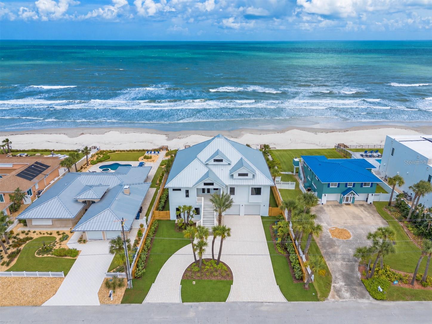 Direct Oceanfront mansion on prestigious Van Kleeck Drive! This masterpiece estate home is almost completed with most everything new year 2025-2026.  Renovated with a recently installed 80ft seawall, pool, spa, paver deck and landscaping. A professional interior designer has created her crowning achievement with this spectacular oceanfront estate! It has 4 Bedrooms, 4 ½ Baths, plus room for a first floor "nanny flat”.  Entertain even the largest family with plenty of room to spare. On the 2708 sq ft main level (second floor) are the kitchen with center island, dining and living spaces plus master suite, laundry room, second bedroom and bath.  The kitchen has wood cabinets, quartz countertops, and top of the line SKS luxury appliances, plus a spacious walk-in shelved pantry.  The main level also has a huge east facing deck accessible by sets of sliding doors from the living area. Upstairs are two more bedrooms and baths with an additional east facing deck giving phenomenal views. Downstairs consists of a two car garage, a very large storage area, an even larger flex room with doors opening to a beautiful pool/spa backyard. Private stairs descend from the primary level to the patio pool and beach. This feels like a secluded and tropical beach home. This luxurious home was taken down to the studs and rebuilt; it presents itself like new construction.  Easy to view with short notice and well worth the visit!