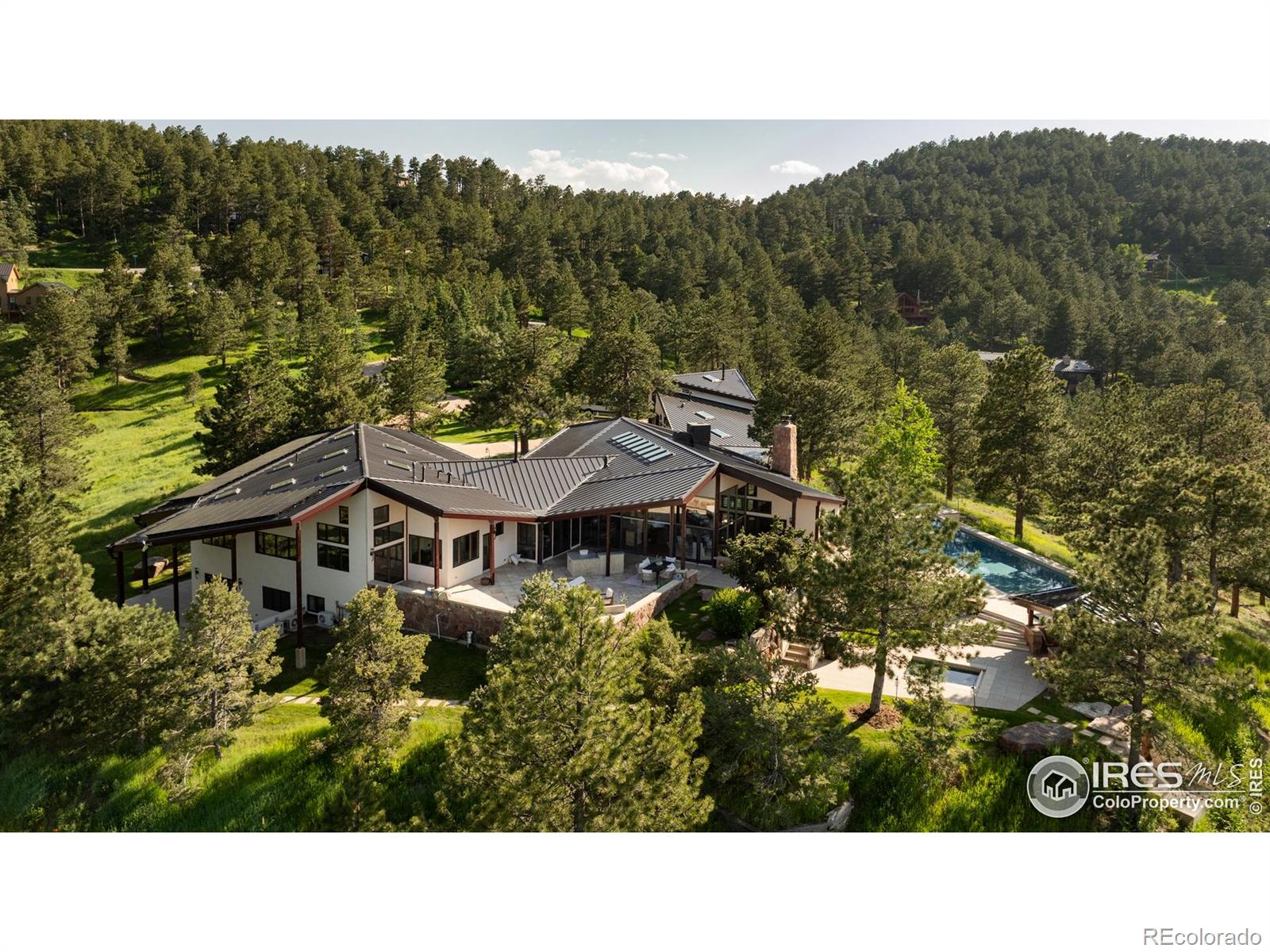 One of Boulder's most prestigious properties! Introducing the Ponderosa Mountain Estate, a prestigious 10.6-acre retreat just minutes from Downtown Boulder and Pearl Street Mall. Designed by renowned architect Hobart D. Wagener, this property includes an elegant main residence, a private guest apartment, and lush landscaped grounds. It offers a unique indoor-outdoor lifestyle ideal for relaxation, entertaining, and outdoor adventures like hiking and skiing. The 7,016 square-foot main residence is bathed in natural light, featuring Brazilian cherry hardwood and stone flooring, and redwood cedar ceilings with skylights. The vast great room is perfect for relaxation, with multiple fireplaces and bespoke cabinetry. Enjoy the gourmet kitchen with custom cabinetry, soapstone counters, and top-tier appliances like a Wolf range and Sub-Zero refrigerator. Adjacent spaces include a kitchen lounge, a cozy library, and an inspiring art studio. The lower level hosts a home theater, snack bar, garden-level office/bedrooms, and a massive laundry room. The main-floor owner's suite offers a private sitting room, wood-burning stove, and a luxurious spa bathroom. Additional accommodations include secondary bedrooms and a garage guest apartment with a chef's kitchen and home gym. Situated on a prime hilltop lot, the estate enjoys breathtaking views and year-round sunshine. Outdoor amenities include a swimming pool, sauna, hot tub, and a private hiking trail. The property is designed with extensive infrastructure, including two water supplies (Pine Brook Hills water and well), a sophisticated home automation system, and security features for ultimate comfort and safety. Experience unparalleled living in this exceptional Boulder sanctuary.