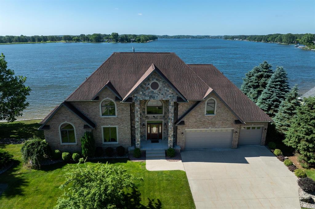 Welcome to luxury lakefront living at its finest! This beautiful waterfront home is located on Lake Isabella, a private 800-acre all-sports lake. This 4-bedroom, 4.5-bath custom residence with a 3-car garage sits on a professionally landscaped 1-acre lot with 210 feet of shoreline. Built to the highest standards, the home features a brick and real stone faƒ §ade, granite countertops throughout, and a stylish blend of ceramic tile, marble, hardwood, and carpet. The grand two-story foyer opens to a spacious great room with cathedral ceilings, a natural stone fireplace, and a dramatic wall of windows showcasing breathtaking lake views. The open-concept layout connects the great room, breakfast nook, and kitchen, which features a lake-facing center island. A formal dining room and wood-paneled study-both with water views-offer additional elegant living spaces. The first-floor primary suite includes cathedral ceilings and a walk-in closet, while the second floor boasts a guest suite with a private lake-view balcony. An exposed catwalk connects the suite to a large loft, two additional bedrooms, a full bath, and a second study. The finished walkout lower level is ideal for entertaining, offering a wet bar with granite counters, pool table, home theater with Bose sound system, and an infrared sauna. A sliding door leads to a patio, stone-lined seawall, and sandy beach. Energy-efficient with 2x6 exterior walls, Anderson windows, geothermal heating and cooling, and a standby whole-house generator. Enjoy over 500 sq ft of composite decking across the lakeside of the home. As a member of the Isabella Property Owners Association, youll have access to The Pines Golf Course with clubhouse and restaurant, private airstrip, tennis courts, 22+ parks, and a campground with adjacent storage facilities. This home blends timeless elegance with modern comfort.