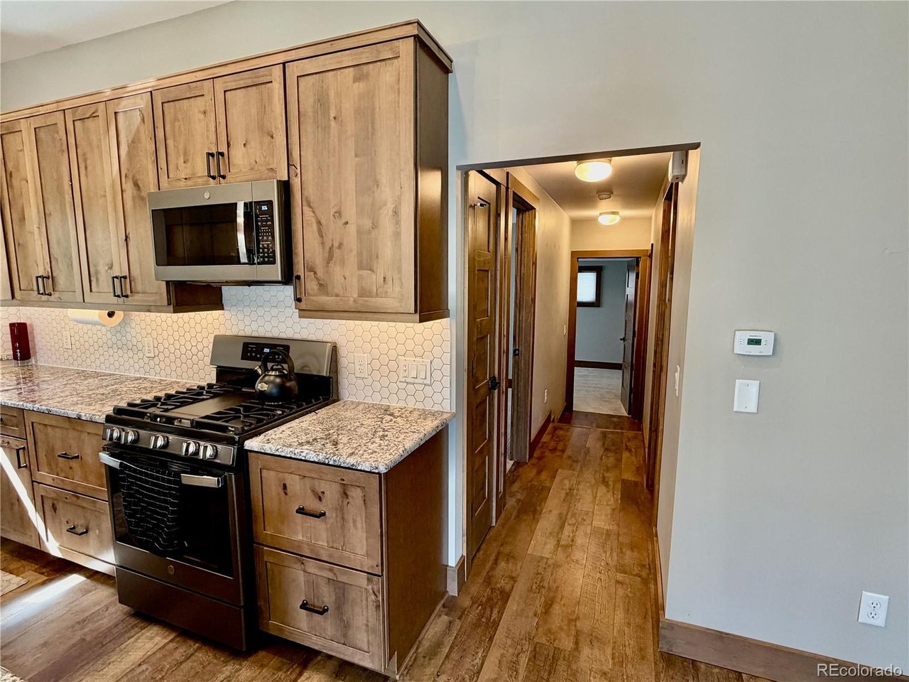 Come discover 817 Big Horn Drive - your opportunity to own a beautifully renovated single-level ranch home on a generous 0.51-acre lot in one of Estes Park's quietest, most established neighborhoods. At 1,859 sqft, this 3-bedroom, 2-bath residence has been professionally remodeled with a mountain modern flare.   Step inside to an inviting, open-concept layout filled with natural light and hard to find single level living. The heart of the home features a completely updated kitchen ideal for everyday meals and gatherings, complemented by fresh flooring and contemporary finishes throughout. Relax in the expansive living area where big windows bring the outdoors inside. Retreat to the spacious primary suite with its luxurious updated bathroom. Two additional bedrooms and a second full bath provide flexibility.   Outside, the mature trees, beautiful landscaping including rare lush green grass, and a secluded patio with unique rock outcroppings create the perfect spot for enjoying Estes Park's outdoor living at its finest. It has a two-car attached garage with oversized loft for storage. In addition to the cosmetic updates major system updates include new roof, plumbing, electrical, and HVAC meaning true turnkey living with peace of mind for years to come.   Conveniently located just minutes from downtown Estes Park, local shops and restaurants, and the entrance to Rocky Mountain National Park, this home blends serene neighborhood living with easy access to everything the area offers.   This stunning home is ready for its next chapter. Come see why this like-new mountain retreat stands out!