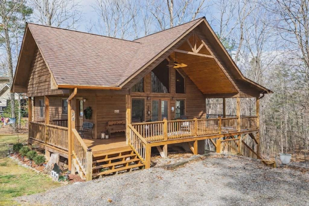 Warm and inviting 2BR/3BA cabin tucked away in a quiet, well-kept mountain community with paved roads approximately five miles from historical downtown Murphy and just one mile from the marina on Lake Hiwassee.   Enjoy easy access to boating, fishing, and water recreation, with the public boat ramp and picnic areas at Hanging Dog Recreation Area just minutes away — making this an ideal location for lake lovers and outdoor enthusiasts.    Step inside to soaring tongue-and-groove wood ceilings, expansive windows, and a stunning stacked stone fireplace that anchors the living space, creating classic chalet-style character paired with the comfort and convenience of main-level living.   The main level features two bedrooms and two full baths, including a private primary ensuite, along with an open-concept living, dining, and kitchen area designed for gathering and everyday enjoyment.    The fully finished lower level expands the living space with a spacious family room, bonus room, and third full bath — perfect for guests, movie nights, or flexible use as a home office, hobby space, or additional sleeping area.     Thoughtful upgrades include a dual-fuel HVAC system with built-in dehumidifier, whole-house water filtration system, copper gutters, fiber optic internet, and exceptionally low utility costs, offering a combination of efficiency, durability, and year-round comfort.   Outside, unwind on the wrap-around covered porches and enjoy the fenced yard for pets, all surrounded by peaceful mountain charm and natural beauty.    Whether you're seeking a full-time residence or get-away retreat, this cabin offers a lifestyle centered around outdoor living and relaxation.