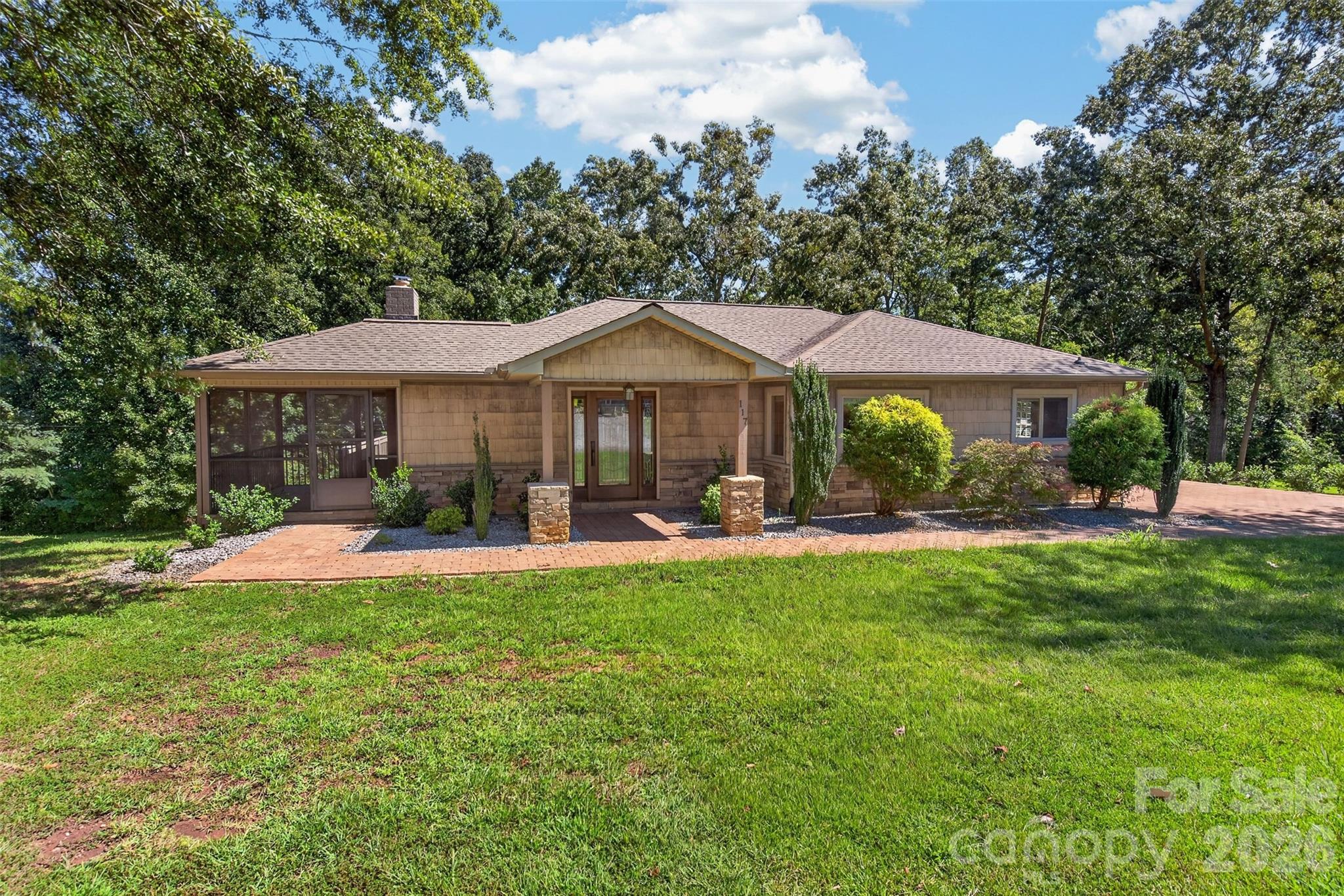 Absolutely beautiful, well-maintained home on quiet Edgewood Avenue, within walking distance of downtown Landrum. Built during the golden-era of construction, this easy, low maintenance home is on a triple lot. Enjoy the extra room, or use the extra lots to build! Walk through the front door and be greeted by gorgeous hardwood floors, a cozy wood stove insert, and a relaxing screened porch off the living room. To the right of the living room, the eat-in dining area flows into the kitchen. Natural light pours through every window! Refrigerator was replaced earlier this year, and the stove is brand new! Full, unfinished basement has unlimited possibilities! All new insulation in the attic. Wrap-around deck. Large 16x20' shed is in the backyard. Generator sub-panel helps you be ready for potential outages. Plenty of parking is available in the driveway. Additionally, you can pull a vehicle down through the back yard. Come see this incredible home today!