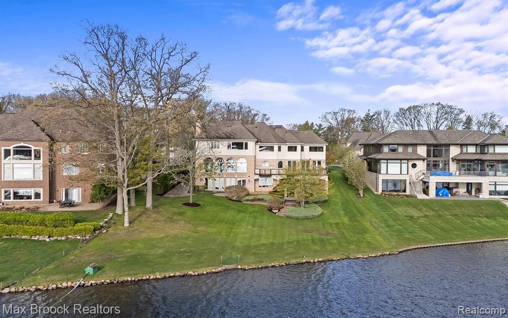 Perched above the shoreline with sweeping, unobstructed views, this exceptional home offers 120’ of frontage on all-sports Upper Long Lake. The setting is truly spectacular, providing a vantage point over the water while maintaining an expansive lakeside lawn. A stately brick facade, circular driveway and brick paver motor court provide impressive curb appeal. Dual glass front door entry. Two-story marble foyer opens to a grand living and dining area framed by a wall of floor-to-ceiling arched windows. Handsome library featuring built-ins. Wet plaster crown moldings. Chef’s granite kitchen with arched lake-view windows, center island with countertop seating, Sub-Zero refrigerator, Thermador five burner cooktop, GE double oven, two Bosch dishwashers and a walk-in pantry. Family room mahogany built-ins and floor-to-ceiling windows. Marble and granite half baths on the entry level. Primary suite vaulted tray ceiling, panoramic lake views, boutique-style walk-in closet with center island, dressing vanity and marble bath with dual vanity and steam shower. Three additional bedroom ensuites upstairs all with walk-in closets and lake views. Second floor bonus room with skylights and second floor laundry. Walkout lower level floor-to-ceiling windows and doorwall featuring a full second kitchen, family rec room, billiards area, bedroom ensuite and an additional laundry room. All solid core interior doors. Full home generator, central vac. Impeccably landscaped setting with tiered brick paver patios, manicured gardens and an Ipe Brazilian Walnut deck with glass railings positioned to capture panoramic lake views. Three car garage. Bloomfield Hills Schools: Lone Pine Elementary, South Hills Middle, Bloomfield Hills High. Quality construction and commanding views from every room on one of Bloomfield Township’s most coveted lakefront streets!