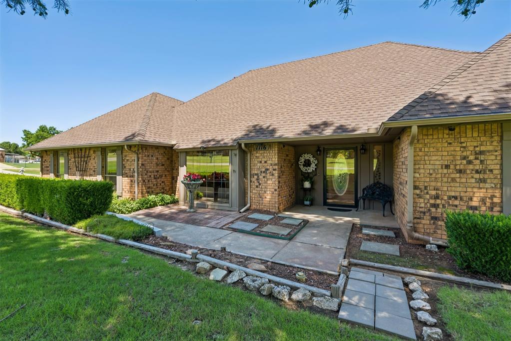 Nestled on a picturesque one-acre corner lot, this beautifully maintained 3-bedroom, 2-bath home offers timeless charm, thoughtful design, and inviting outdoor living. Lovely shade trees, privacy landscaping, manicured flower beds, a pergola, decorative lighting, a bench swing, and stone accents create a park-like setting you'll enjoy year-round. A spacious covered back patio with ceiling fans and lighting provides the perfect space for entertaining or relaxing. The home welcomes you through an elegant front door featuring decorative glass. Inside, a formal dining room with a built-in China cabinet sets the stage for memorable gatherings. The expansive living room showcases an elevated ceiling, plush carpeting, built-in shelving, a striking brick hearth, and a cozy wood-burning fireplace. The well-appointed kitchen features quartz countertops, a tile backsplash, abundant cabinetry, recessed lighting, an elevated ceiling, and a built-in Jenn-Air smooth-top cooktop with downdraft ventilation. A sunny breakfast area provides additional dining space, while solar tubes fill the home with natural light. The laundry room offers extra workspace and storage, and the hallway is accented with wood flooring and built-in cabinetry. Two comfortable guest bedrooms feature carpet and ceiling fans. The guest bath is beautifully appointed with tile countertops and flooring, crown molding, decorative wallpaper, a solar tube, a unique stained-glass window, and a tub/shower combination. The spacious primary suite offers a large bay window, ceiling fan, built-in wall lighting, patio access, and a peaceful retreat. The ensuite bath includes dual sinks with tile countertops, tile flooring, skylight, a walk-in shower with sliding glass doors, a large soaking tub, and an oversized walk-in closet. Completing the property is a two-car garage and an exceptional blend of comfort, character, and privacy, making this home a rare opportunity for those seeking peaceful living with timeless appeal.