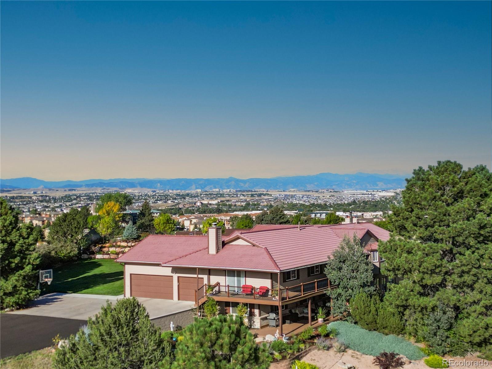 Set on 4.5 elevated acres in Sierra Vista, this walk-out ranch was designed for a life lived between mountain sunsets and morning swims. Panoramic western views pour through new walls of glass, expansive covered decks extend the living spaces outdoors, and a year-round heated indoor pool transforms daily routine into a private wellness retreat, all just three miles from the restaurants, boutiques, and conveniences of downtown Parker with effortless access to E-470 and Denver International Airport.Inside, over 5,700 square feet of reimagined living space unfolds with intention and scale. The main level is anchored by a massive great room where rich hickory floors ground the space and a high-efficiency wood-burning fireplace adds warmth and architectural presence. Expansive new windows and glass sliders frame the mountains as living art, while multiple access points create seamless flow to the covered decks,  blurring the boundary between indoors and out.The single-story layout offers three bedrooms on the main level, including a private primary suite with its own fireplace, five-piece bath, and direct deck access, reinforcing both comfort and connection to the landscape.The finished walk-out lower level expands the experience with two additional bedrooms, a spacious secondary living area, and a dedicated fitness room complemented by a steam spa shower. With direct outdoor access, the lower level lives with the same ease as the main floor, offering natural flexibility for guests, multigenerational living, or a private wellness suite.Beyond its setting, the true value lies in execution. The renovation is cohesive. The layout is intuitive. The scale is balanced between openness and privacy. This is a home designed not simply to impress, but to function beautifully, comfortably, and without excess.Additional features include a 3-car garage, a Quarrix composite roof, two furnaces, an underground dog fence, an outdoor putting green, and horses permitted.