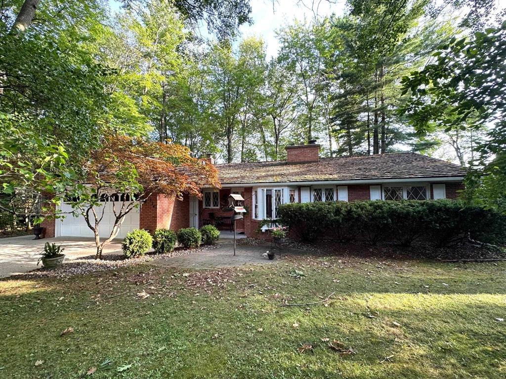 Brick Ranch Lakefront Home on a quiet cul-de-sac and nestled in a subdivision renowned for its tranquility and upscale homes. With 1,428 square feet of living space, this full brick home boasts exceptional curb appeal, featuring landscaped gardens adorned with shrubs and a variety of perennials. Enjoy the convenience of an attached garage, a separate workshop with an attached garden shed. Both the garage and workshop offer steps for overhead storage. The property boasts a remarkable 80 feet of prime lakefront on Houghton Lake, Michigan's largest inland lake, providing an idyllic setting for relaxing and entertaining. Step inside to discover a bright four-season sunroom with panoramic views of the lake and breathtaking sunsets. The spacious living room is highlighted by a full wall stone gas log fireplace and vaulted ceilings, creating a warm and inviting atmosphere. Sliding doors lead to a lakeside deck for outdoor enjoyment. The kitchen features a tastefully designed brick wall with a built in refrigerator and an eye-level oven. There is also a Jenn Aire cooktop, a dishwasher, disposal and a cozy dinette. This home includes three comfortable bedrooms and two full baths, along with a laundry room for added convenience. Stay safe and comfortable year-round with a natural gas hot water baseboard heating system and a Generac generator. This property truly offers a perfect blend of comfort and lakeside living, making it an exceptional opportunity in a quiet and secluded neighborhood.