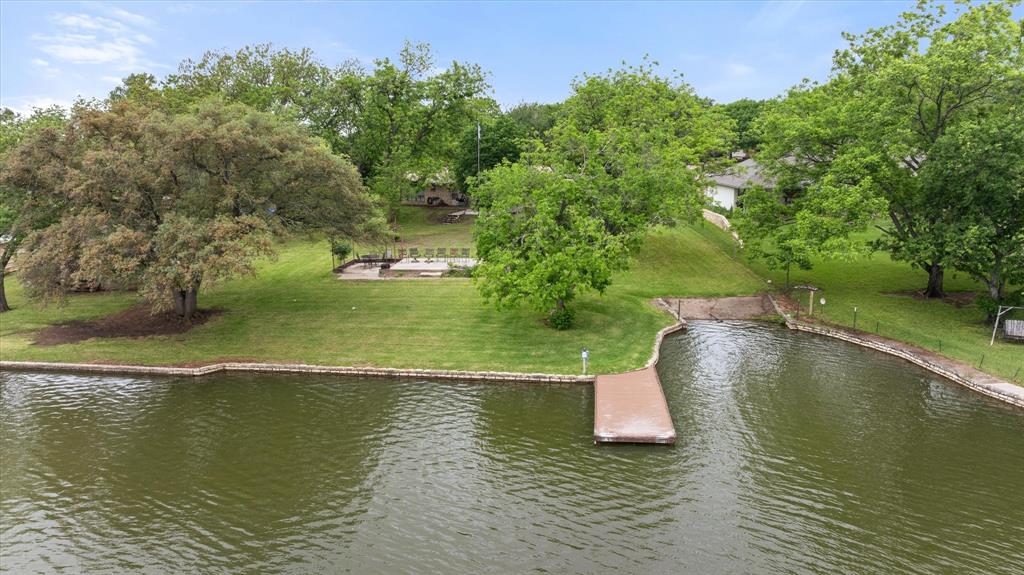 VACATION. INVESTMENT. HOME. Why choose when you can have it all? Welcome to 633 Bridge Street — one of Granbury's most coveted addresses, where lakeside living meets the heartbeat of downtown. Sitting right on the water with 1,704 square feet of comfortable, easy-living space, this single-family gem delivers the kind of lifestyle most people only dream about.Step outside and you're moments from dining, shopping, parks, the historic square, and everything that makes Granbury one of Texas's most charming destinations. Step inside and you have your own private lakeside retreat. This is the rare property that checks every box — whether you're searching for a primary residence, weekend escape, or a high-demand short-term rental opportunity.Properties like this don't come around often. Downtown Granbury lakefront homes are a rare commodity, and once they're gone, they're gone. If you've been waiting for the perfect blend of location, lifestyle, and long-term value — your wait is over.BRING ALL OFFERS — Granbury living at its finest is right here at 633 Bridge Street.