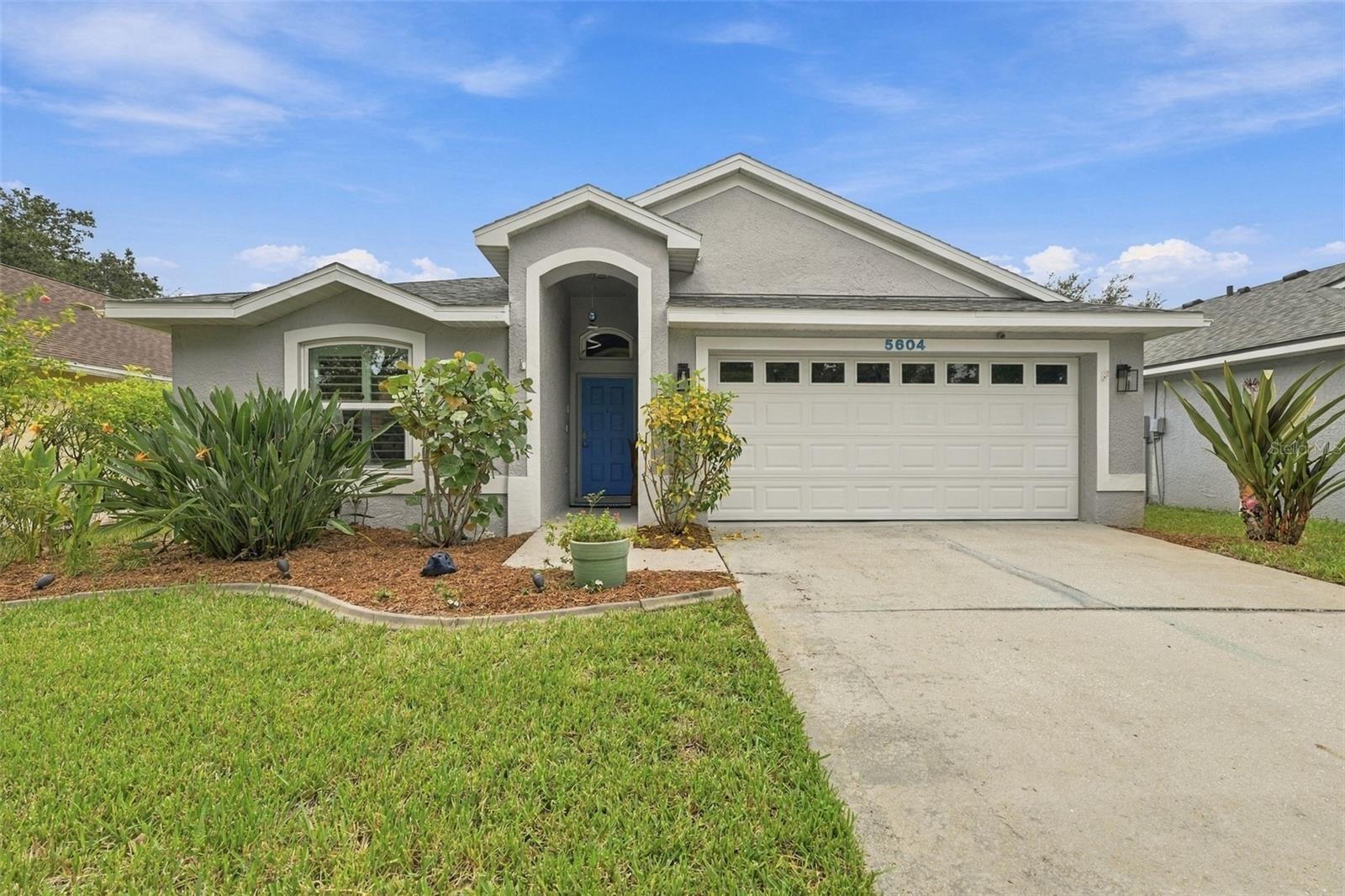 Welcome to 5604 Tughill Drive, a beautifully maintained 3-bedroom, 2-bath home offering an open, split-bedroom floor plan and an impressive indoor-outdoor living setup in a convenient Tampa location. Vaulted ceilings, abundant natural light and waterproof luxury vinyl plank flooring create an open and inviting feel throughout the main living areas.The kitchen features custom solid-wood hickory cabinetry with soft-close doors and drawers, granite countertops, pull-out pantry storage, stainless steel appliances, a deep single-basin sink and pendant lighting. The kitchen opens directly to the spacious living and dining areas, making the layout ideal for both everyday living and entertaining.One of the home's standout features is the approximately 1,000-square-foot screened paver patio, creating an expansive outdoor living area that feels like a true extension of the home. Surrounded by tropical landscaping and a privacy fence, the backyard is designed for low-maintenance Florida living with plenty of room to relax, dine and entertain.Additional improvements include impact-resistant vinyl windows, plantation shutters, updated baseboards, knockdown ceilings, ceiling fans throughout, a Carrier HVAC system with Infinity controls and UV light, an electric on-demand whole-house water heater and an electrical transfer switch for generator use. The two-car garage provides additional storage with installed shelving and attic flooring.Located less than a mile from access to the Veterans Expressway and convenient to Tampa International Airport, shopping, dining, Raymond James Stadium and everything Tampa has to offer, this home combines a central location with a private, low-maintenance setting and exceptional outdoor living space.