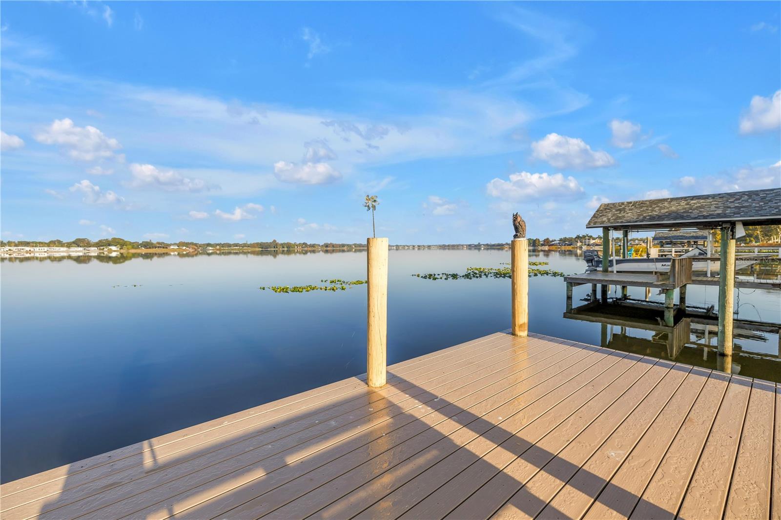 Gorgeous WATERFRONT 4 bedroom pool home in LAKESIDE ESTATES! Imagine having your morning coffee relaxing on your private dock overlooking LAKE SEMINOLE, a freshwater fishing paradise. Most rooms have views of the water! The living room, kitchen and primary bedroom overlooks BOTH the pool and the lake. Eat-in breakfast nook feature glass sliding doors that lead you to your pavered pool deck. HUGE under-roof patio that provides plenty of room to enjoy the outdoor space. Primary bedroom has an inviting en-suite bathroom with granite countertops, ample vanity space with dual vanities and also features his & her closets. All rooms are generously sized. Your guest bathroom is also a great pool-bath with direct access to your pavered patio. Excellent floorplan, vaulted ceilings, and split bedroom layout provides privacy for everyone. The pool features an updated screen enclosure - Screen enclosure re-screened (2024). Large waterfront lot - Still plenty of yard space to play catch or fetch or to just putter in your garden. Dock has a spacious platform with a bench, perfect area to relax with friends! The kitchen has been updated with hardwood cabinets, granite countertops, dedicated pantry with pull-outs, a breakfast far for casual dining and has a great view of the pool! The kitchen is open floor plan so the chef is always part of the fun! Family room features a cozy wood burning fireplace. Spacious inside utility room with included washer, dryer and utility sink. Oversized garage and extra wide driveway! Recent upgrades include New AC (2025), New Roof (2020), New composite dock (2024), Screen enclosure re-screened (2024), Chimney cap & flue replaced (2020), New pool pump (2020), Fridge and microwave new (1-2 years old), Swisstrax garage flooring system, New gutters and downspouts added, New floor in half bath, Pool deck repainted. No problems from the 2024 storms. Lakeside Estates is an established, deed restricted neighborhood with sidewalks, streetlights and is comprised of beautifully kept custom homes. Located about 15 minutes from world famous beaches, and about 30 minutes to Tampa International airport or Downtown St. Pete.