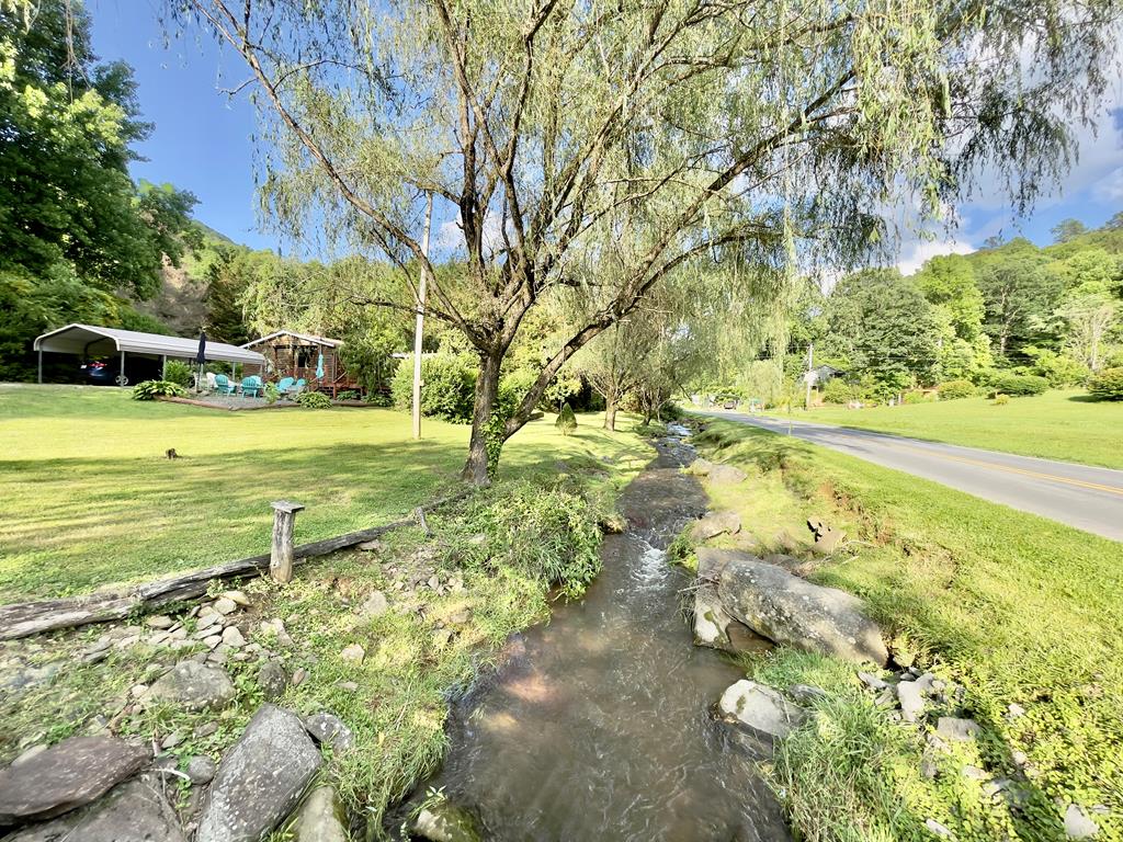 Charming retreat sitting right on Yellow Creek! Discover the perfect blend of comfort and nature with this stunning 1-acre creekfront lot, conveniently located with easy access off Yellow Creek Road. This property features a level, usable yard, ideal for outdoor activities or simply relaxing by the creek. The home has a permanent, block foundation/crawlspace and wood siding on the exterior. Enjoy year-round comfort with central heating and air conditioning, open living/dining, 3 bedrooms, 2 baths and laundry room. Step outside to unwind on the inviting open front deck or enjoy the privacy of the covered back porch, perfect for morning coffee or evening relaxation. The property also includes two metal carports for your vehicles and a handy storage building for all your outdoor gear. Location is key, and this property doesn't disappoint! You'll be just a minutes away from the famous Hwy 129 The Dragon, as well as the Historic Tapoco Lodge, Lake Santeetlah, Fontana Dam, and countless recreational opportunities.