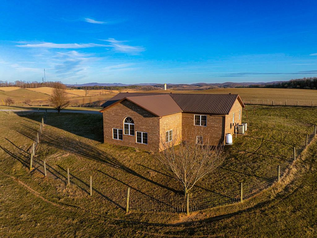 A stunning custom-built contemporary home set on 2 picturesque acres, this 3-bedroom, 2.5-bath home blends modern design with breathtaking natural surroundings. Resilient walnut flooring flows throughout, complemented by thoughtfully curated custom tile work that elevates every space. Expansive windows capture sweeping 360-degree views, filling the home with natural light and creating a seamless connection to the outdoors. The open, airy layout is perfect for both everyday living and entertaining. Outside, the property is a dream for those seeking space and self-sufficiency, featuring established grapevines, mature apple and pear trees, and fencing ideal for farm animals. A rare opportunity to enjoy contemporary comfort with the freedom and beauty of country living.