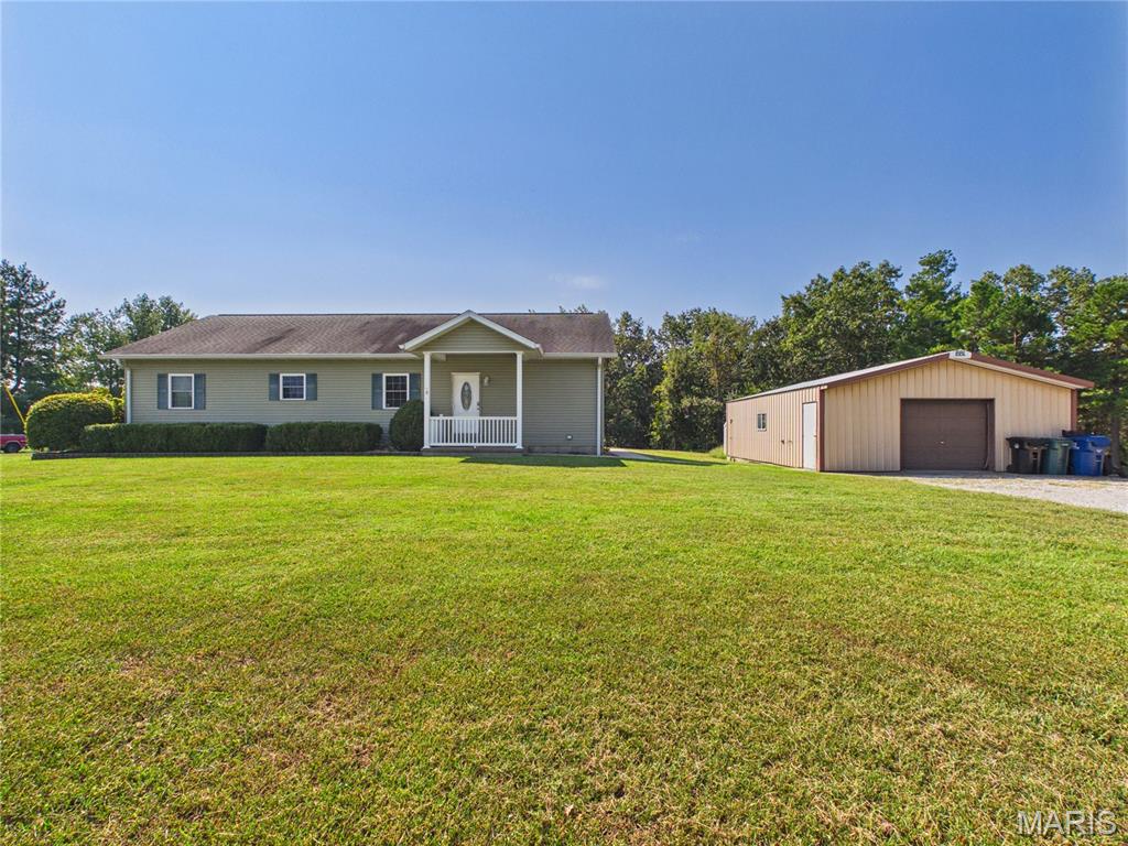 Welcome home to the perfect combination of space, comfort, and versatility! Built in 2007 and situated on 3 acres, this well-maintained 3-bedroom, 3-bathroom home offers an inviting open-concept layout, thoughtful updates, and plenty of room both inside and out. The main level features an open-concept living, dining, and kitchen area, creating a comfortable space for everyday living and entertaining. The kitchen offers a center island. Convenience continues with main-level laundry and a spacious primary bedroom complete with a walk-in closet and a brand-new remodeled primary bathroom featuring an oversized walk-in shower. The mostly finished full basement, completed within the last five years, adds incredible additional living and entertaining space. With 10-foot ceilings, an island, cabinetry, and a newly added full bathroom, this lower level offers endless possibilities for a family room, game room, entertaining space, hobby area, or whatever best fits your lifestyle. A convenient walk-up provides easy access to the outdoors, while the additional bathroom brings the home's total to three. Step outside and enjoy the covered back patio, the perfect spot to relax, entertain, grill, or simply enjoy the peaceful surroundings and your 3 acres. And for those needing workspace, storage, or room for hobbies and projects, the 30' x 24' concrete detached shop/shed is an incredible bonus and adds even more versatility to this property. With 3 acres, 3 bedrooms, 3 bathrooms, a spacious finished basement, a beautifully remodeled primary bathroom, main-level laundry, an open-concept design, outdoor living space, and a substantial detached shop, this property offers flexibility that is hard to find. If you've been looking for a home with room to live, room to entertain, and room to make it your own, this one deserves a closer look!