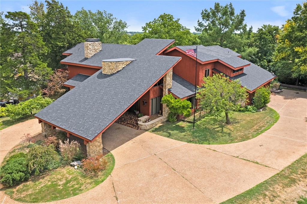 Step into a one-of-a-kind custom-built mid-century modern masterpiece offering incredible space, architectural character, and endless possibilities. Tucked away on a quiet cul-de-sac, this expansive home was thoughtfully designed with multiple living areas, unique entertaining spaces, and flexible layouts ideal for today’s evolving lifestyle needs.From the moment you enter, you’ll be captivated by the stunning floor-to-ceiling stone fireplaces, dramatic architectural lines, and walls of windows that bring warmth and natural light throughout the home. The interior greenhouse creates a truly distinctive focal point, blending indoor living with natural beauty in a way rarely found.With generous square footage, private living spaces, and exceptional versatility, this property offers exciting opportunities for multi-generational living, extended guest accommodations, creative studio space, or even the potential for short-term rental income opportunities. Every room offers its own personality and purpose, creating an experience unlike anything else on the market.Additional highlights include a spacious three-car garage, custom details