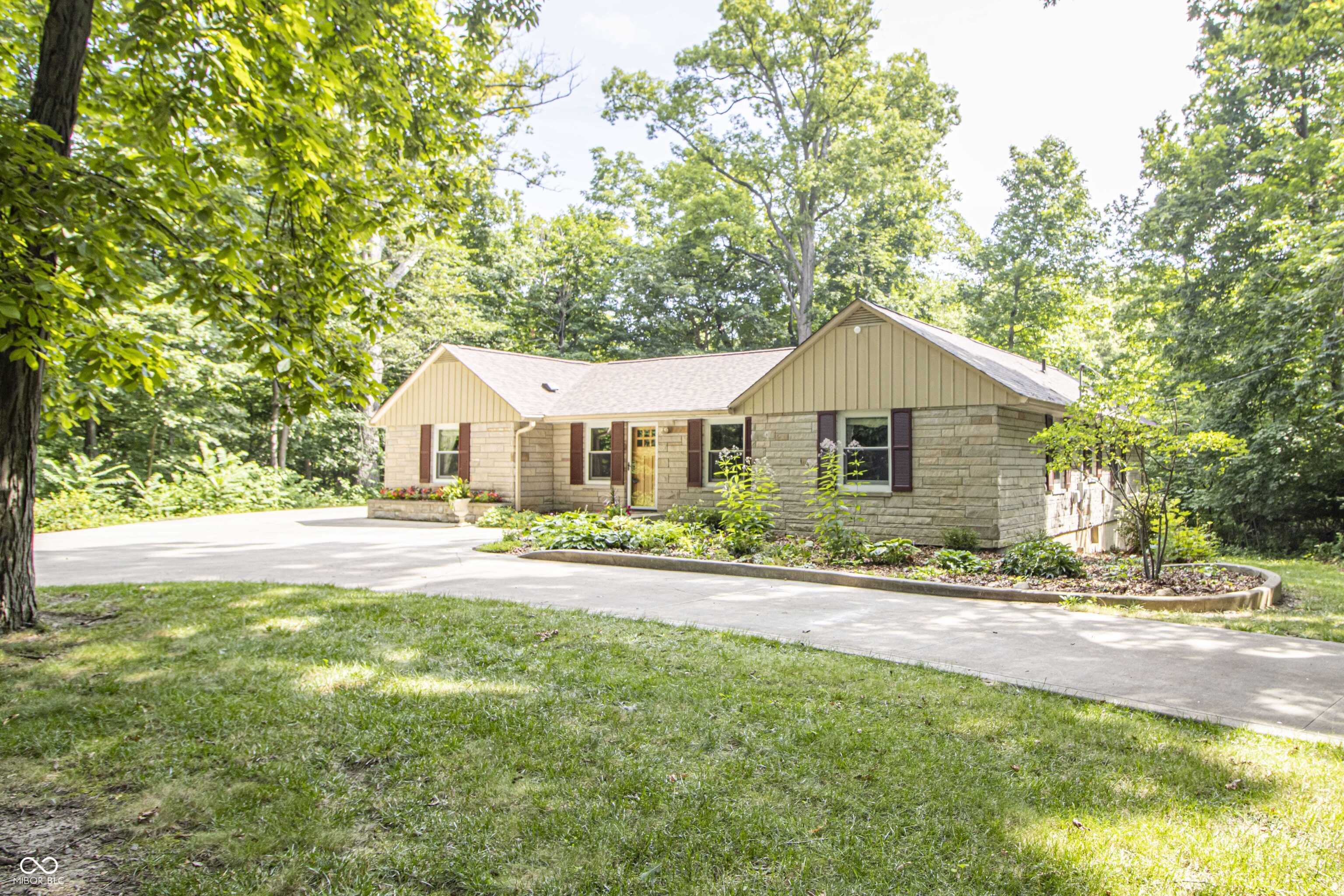1.32 acres of serene ranch living with a walk-out basement awaits you. This meticulously maintained property is packed with high-end upgrades for peace of mind for years to come. Recent improvements include a new roof installed in 2024, geothermal heating and AC added in 2025, and septic pumped in 2024 and Air ducts cleaned in 2026.  Additional updates such as a new iron filter and water purifier in 2023, water heater 2022 along with a new water softener in 2024, provide modern conveniences. The exterior mortar and stone veneer have been checked and repaired as necessary in 2024, maintaining the home's charming appeal. The kitchen received a stunning update in 2017, featuring a beautiful backsplash, a center island, and upgraded appliances. The garage is finished with insulation and epoxy flooring, and the entire home boasts newer Pella windows. Enjoy the durability of a concrete driveway installed in 2014. Inside, hardwood floors flow through many rooms, while a HUGE living room showcases a stone fireplace and large picture windows overlooking a picturesque wooded backyard. The walk-out basement presents an opportunity for further customization and outdoor areas. Explore the gorgeous wooded lots perfect for enjoying nature. HSE Schools, convenient location in Fishers.  This home has been lovingly cared for and is ready for its next owner. Schedule your visit today!