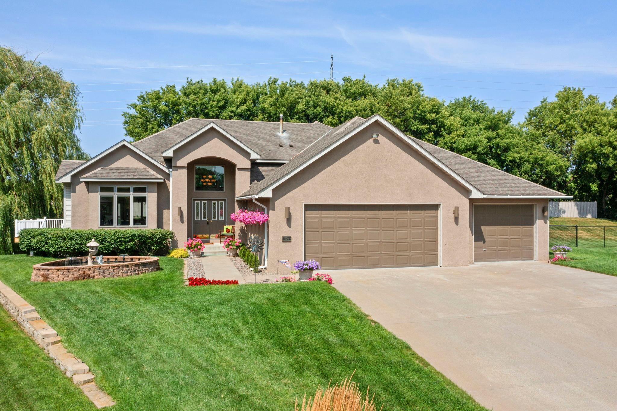 Welcome to this stunning custom-built four-level home featuring three bedrooms and five bathrooms, perfectly situated on a quiet cul-de-sac in Maple Grove, just minutes from shopping, dining, parks, and local amenities. Exceptional curb appeal welcomes you with meticulously maintainedlandscaping, a beautiful front yard fountain, and a thoughtfully designed interior filled with natural light. The foyer features soaring 14-foot ceilings and opens to the spacious living room with floor-to-ceiling windows, carpeting, and a gas fireplace.The updated eat-in kitchen (2022) offers abundant maple cabinetry, expansive counter space, tile flooring, pantry storage, cooktop, double ovens, and a sunny dining area with deck access. The adjacent formal dining room features 10-foot ceilings, elegant finishes, and peaceful neighborhood views. A convenient laundry, 1/2 bathroom and mudroom leads to the impressive heated 1,250-square-foot attached three-car garage featuring epoxy floors, extensive shelving, 8-foot garage doors, and a workshop/office space that could be converted into a fourth stall. The upper level includes two spacious bedrooms, each with a private ensuite bathroom. The primary suite offers double-door entry, a large walk-in closet with built-in organizers, and a spa-like bathroom with dual vanities, jetted soaking tub, and separate walk-in shower. The basement Level 1 offers additional living space with a family room, generous storage, crawl space access, and a third bedroom complete with a walk-in closet and private three quarter ensuite bathroom. Just a fewsteps up, Level 2 is designed for entertaining, featuring a spacious family room with a wet bar, surround sound, a gas fireplace, a half bathroom,and walkout access to the patio and fully fenced backyard. The backyard is a private retreat featuring beautiful landscaping, an extensive irrigation system, and both a spacious deck and patio perfect for relaxing or entertaining. Meticulously maintained with documented updates and improvements, this one-of-a-kind Maple Grove home offers exceptional craftsmanship, thoughtful upgrades, and abundant living space.