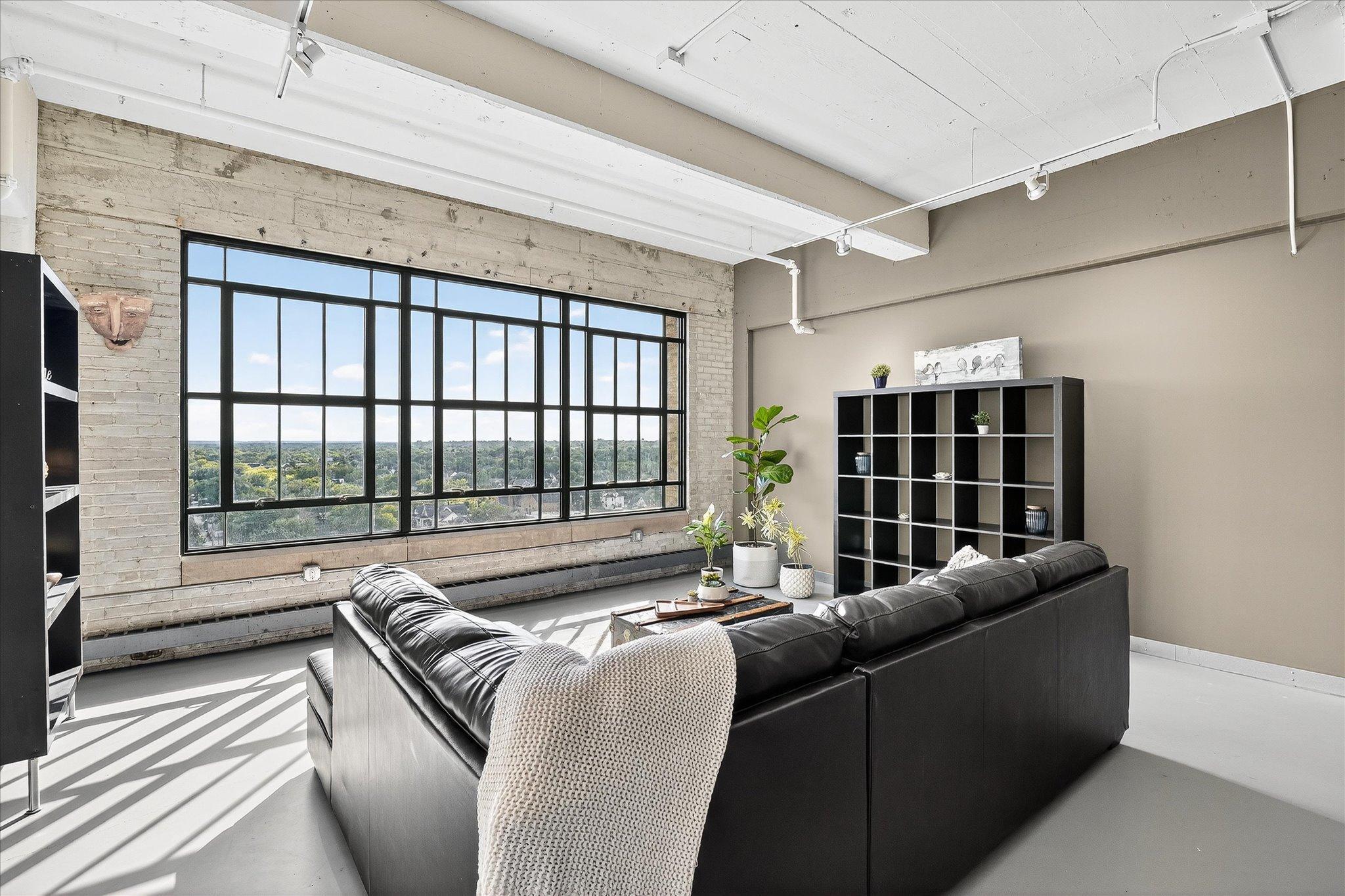 Discover stunning one-level loft living at Chicago Condos, located in the historic Midtown Exchange building. Drive into the private underground resident ramp and take the elevator up to a freshly painted 11th-floor loft featuring soaring 12-foot ceilings, exposed brick, and massive windows that frame breathtaking south-facing views. The unit is outfitted with brand-new, never-used appliances, sleek granite countertops, and updated fixtures. Enjoy the durability of concrete flooring, the convenience of in-unit laundry, a basement storage unit, and one private underground parking space.
Residents have access to a theater/media room, a fully equipped gym, and a rooftop community room complete with a patio, grill, seating, and resident planter boxes—perfect for entertaining or relaxing. Just downstairs, the vibrant Midtown Global Market offers a variety of restaurants, shops, and entertainment options. Outdoor enthusiasts will appreciate the Midtown Greenway trail at the end of the block and Powderhorn Park just two blocks away. With 24-hour security, seamless single-level living, and easy access to freeways and public transportation, this loft offers unmatched convenience and lifestyle. Best of all, pets are welcome in this magnificent property.