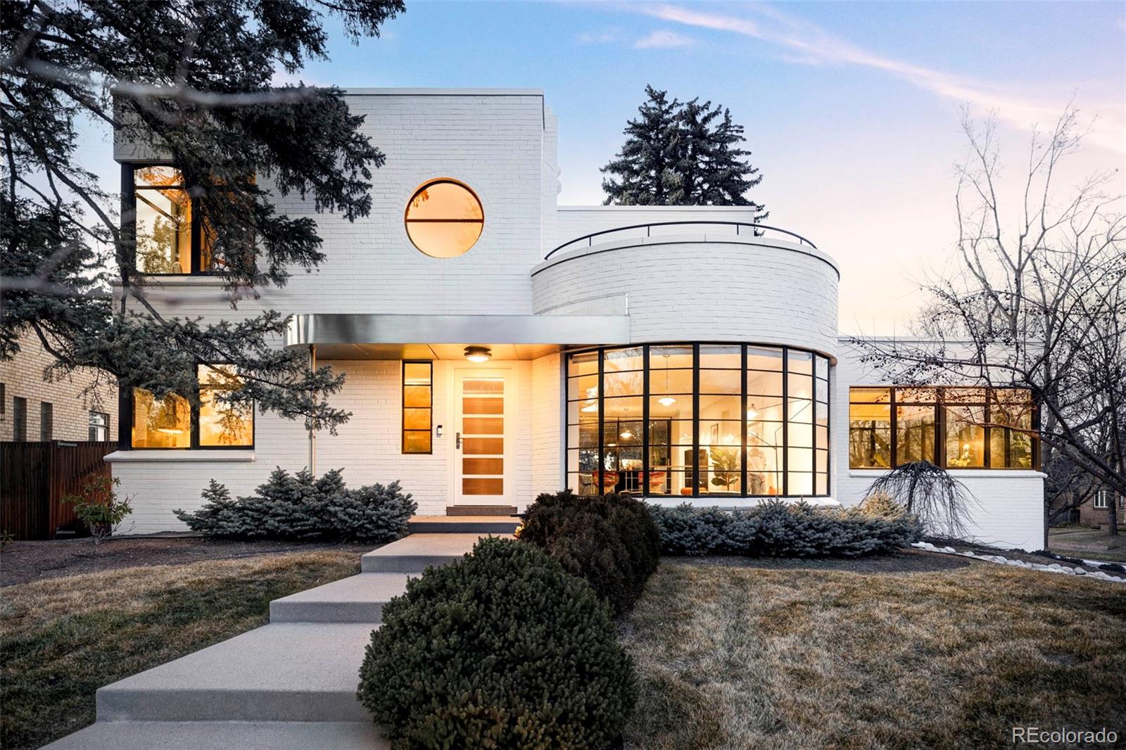 An exceptional expression of restraint, proportion, and material clarity, this International Style Bonnie Brae residence articulates rare design detail and refined livability. Inspired by its 1939 Post-Art Deco origins, then expanded and reimagined by its designer owner with Boss Architecture in 2018, this iconic home occupies a commanding corner lot overlooking Ellipse Park. Inside, main level poured terrazzo floors, quarter-sawn walnut hardwoods, and polished concrete establish a sophisticated foundation. Interior volumes are carefully oriented for natural light and lined with custom built-in furniture, Modernist windows, and rounded architectural edges. The Bulthaup kitchen is organized around a generous island with stainless steel countertops, Gaggenau, Miele, and Sub-Zero appliances, a built-in refrigerator, espresso machine, dual cooktops, and hidden conveniences such as a toe-kick central-vac dust catch, hardwired blinds, Savant smart systems. Indoor-outdoor living is elevated by a heated, covered patio with a built-in grill and integrated sound that extends into the private, elevated backyard. Luxurious baths feature seamless glass + Vitraform sinks, floor to ceiling quartzite, linear drains, heated floors, a steam shower, jetted soaking tub. The primary suite offers an indoor-outdoor retreat with a secluded rooftop garden balcony, fireplace, walk-in wardrobe with island and skylight, and a full laundry suite. This home’s enhanced, comprehensive, wellness-forward systems include HEPA air filtration, a whole-house humidifier, water softener, hot water recirculation, and advanced water filtration with re-mineralizer. Two separate, attached garages for 3 cars, plus a parking pad and driveway offer an expansive motor depot. Abundant custom storage, cedar closets, built-in seating, and a separate workshop create a polished lower level. This stunning home is a contemporary reinterpretation of Bauhaus ideals, executed with scholarly precision.