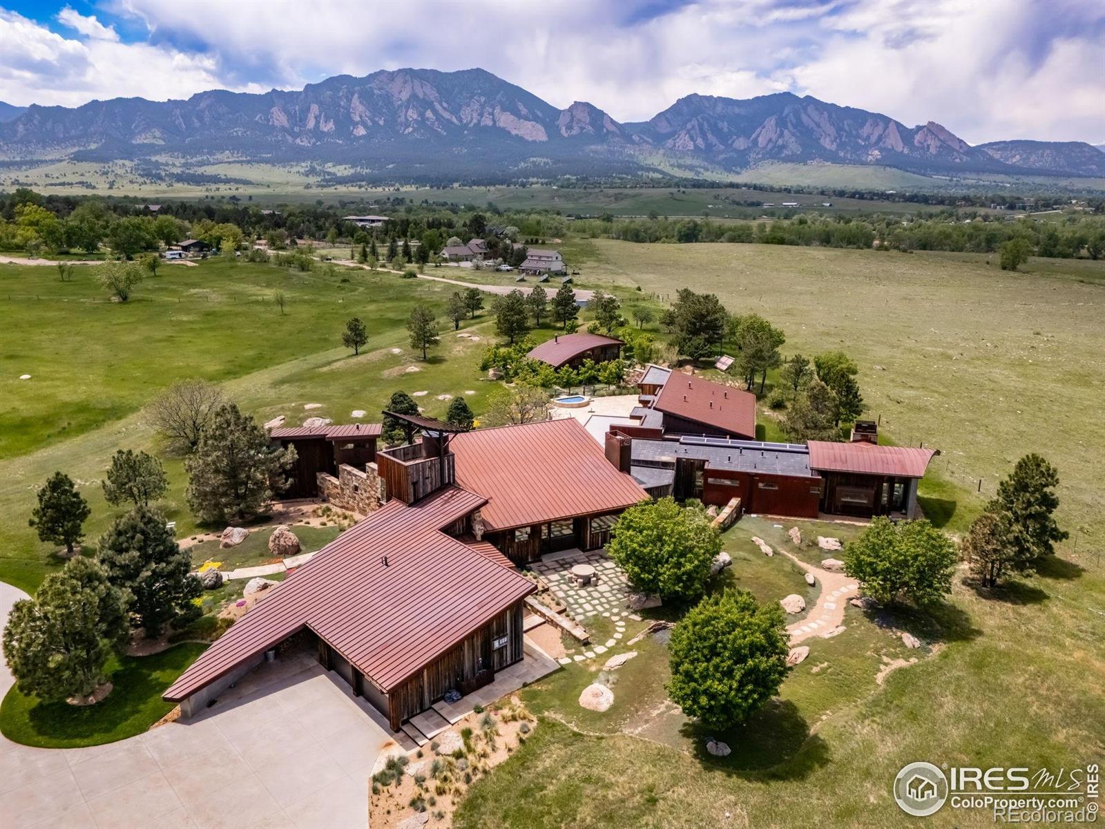 This magnificent offering in south Boulder, Colorado, was purchased in 2005 and has since been developed into a premier equine and residential facility known in the industry as Wildflower Ranch. The residence is an architectural inspiration boldly built with accents of stone, wood, concrete and steel. It sits on a gentle rise commanding panoramic views of the foothills and plains around. A 24 kW PV solar system and an extensive irrigation network is the core of the property's aesthetic appeal. The residence is divided into a social wing, a primary bedroom wing and a kids' wing all within the main building, and a studio/office and a guest house in separate buildings outside of it. The home sits on a gentle rise commanding panoramic views of the foothills and plains around. The horse facilities are centered around a 40x20m indoor arena and a 6-horse barn with 14'x14' stalls on a 64-acre outlot. Other amenities include a second-floor studio, a barn and loafing sheds with runs. Construction ran over a period of years: the barns were built in 2007, the house in 2009 and the arena in 2012. The location is highly desirable with easy access to Boulder, Denver, Denver International Airport and the mountains.