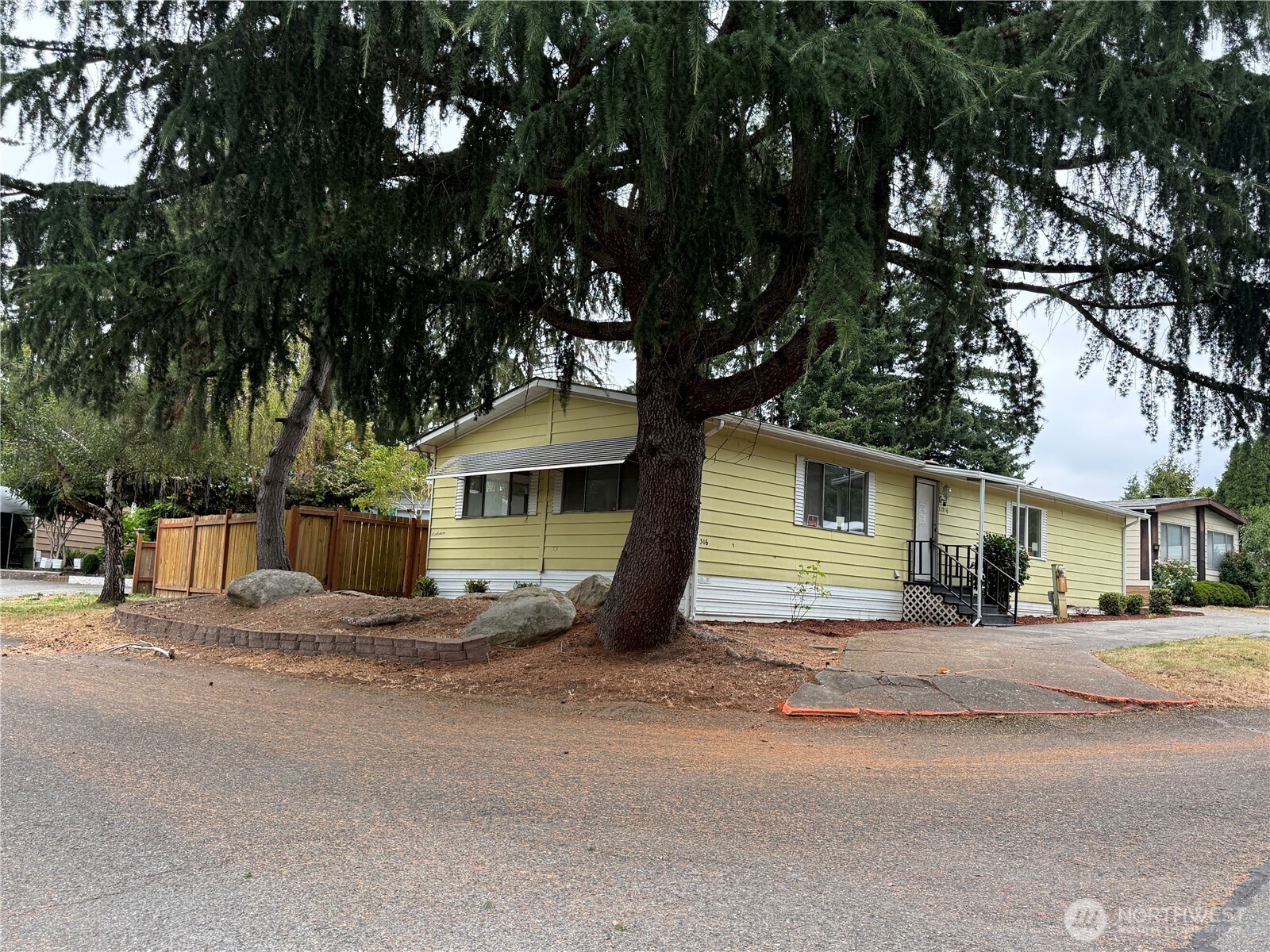 Kenton Firs Community Own your land! Spacious 3-bedroom, 2-bath manufactured home no lot rent, and no age restrictions! You'll enjoy low HOA fees ($200/year) while still benefiting from well-maintained parks and a clean, inviting neighborhood. Inside, a spacious kitchen with eat in area open to the dining area with access through the sliding door to the spacious back deck overlooking the fully fenced backyard. A Bonus storage shed. The primary suite offers a private bath complete with an extra-large soaking tub, separate shower, and walk-in closet. The second bedroom features convenient bath access, and the third bedroom opens directly to the backyard—perfect for guests or a home office. Additional details include ceiling fans, a built in unit in the living room. Bring your fresh ideas-needs furnace repair/replacement, appliances, flooring, and other misc. repairs & updates. Conveniently located close to all amenities, grocery stores, entertainment, parks, etc.