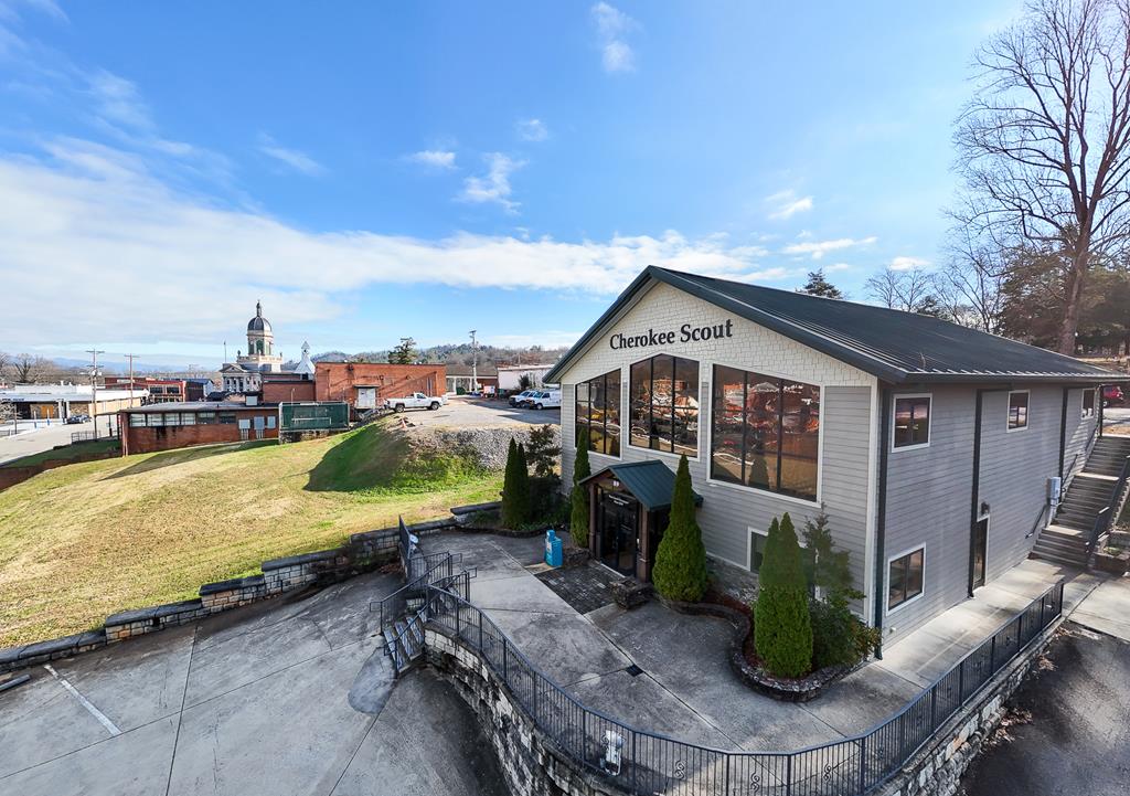 Prominent Commercial Office & Industrial Facility.  A highly visible and versatile commercial property totaling approximately 14,396 square feet under roof, historically home to the Cherokee Scout Newspaper for decades. Strategically located within the Town of Murphy, the property enjoys excellent mountain and Hiawassee River views, strong access to major corridors, and proximity to regional employers and infrastructure.  The offer consists of two complementary buildings situated on approximately 1.52 acres with ample on-site parking and HB zoning, allowing for a wide range of commercial and redevelopment uses.  The 5,768 SF two-story office building, constructed in 2007, is a Class B/C modular metal structure in good condition. The building features multiple private offices, conference rooms, reception and break areas, and clear span accessible layout, modern mechanical systems, and flexible floor plans that allow for single-tenant or multi-tenant reconfiguration.   The 8,628 SF industrial building is a single-story prefabricated metal structure with a brick front office, part constructed in the mid-1960s and expanded over the years. Formerly used as a newspaper printing facility, it offers an open-span warehouse - manufacturing layout, dock-high rear loading, multi-height ceilings, 8" slab and substantial utility infrastructure.  A functional shell well suited for repositioning and presents strong value-add or redevelopment potential.  The property is served by municipal utilities, existing infrastructure, and favorable logistics access, making it suitable for a variety of highest-and-best-use scenarios, including Office with flex or light industrial conversion, Media, technology, or creative studio space, Distribution, storage, or light manufacturing, regional operations or call center, Mixed-commercial redevelopment or adaptive reuse. This represents a rare opportunity to acquire a landmark commercial property in Cherokee County with excellent visibility