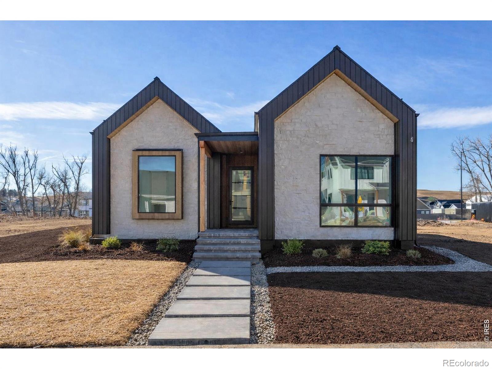 A rare opportunity to own one of Original Town Superior's most distinctive new homes, where modern architecture, refined craftsmanship, and thoughtful luxury come together in an exceptional setting backing to open space and Coal Creek. Striking gable rooflines, curated exterior materials, and a standing seam metal roof create a dramatic yet timeless architectural presence. Inside, expansive windows flood the home with natural light, highlighting wide-plank hardwood flooring and a bright, open layout designed for both everyday living and entertaining. The great room is anchored by a stunning gas fireplace framed by a dramatic two-story tile feature wall, creating a breathtaking focal point. Large glass doors open to the outdoor patio, blending indoor and outdoor living while capturing peaceful open space views. At the heart of the home, the chef's kitchen features custom cabinetry, premium appliances, designer fixtures, and an oversized island perfect for gathering. The primary suite offers a private retreat with generous proportions and a spa-inspired bath featuring elegant tilework, dual vanities, a spacious walk-in shower, and a luxurious freestanding soaking tub. Additional bedrooms are well-sized with tall ceilings and beautifully appointed bathrooms. The fully finished basement expands the home with additional bedrooms, a full bathroom, and flexible living areas for recreation, media, or guests, bringing the home to six bedrooms and four bathrooms. A standout feature is the detached three-car garage with a full accessory dwelling unit above, ideal for guests, multigenerational living, a private office, or rental income. Located steps from the Marshall, Colton, and Coal Creek trail systems and minutes from restaurants, shopping, and everyday conveniences, this home represents a rare blend of design, flexibility, and location. Ask about our Builder Preferred Lender Incentives. Home will be completed by the end of March 2026.