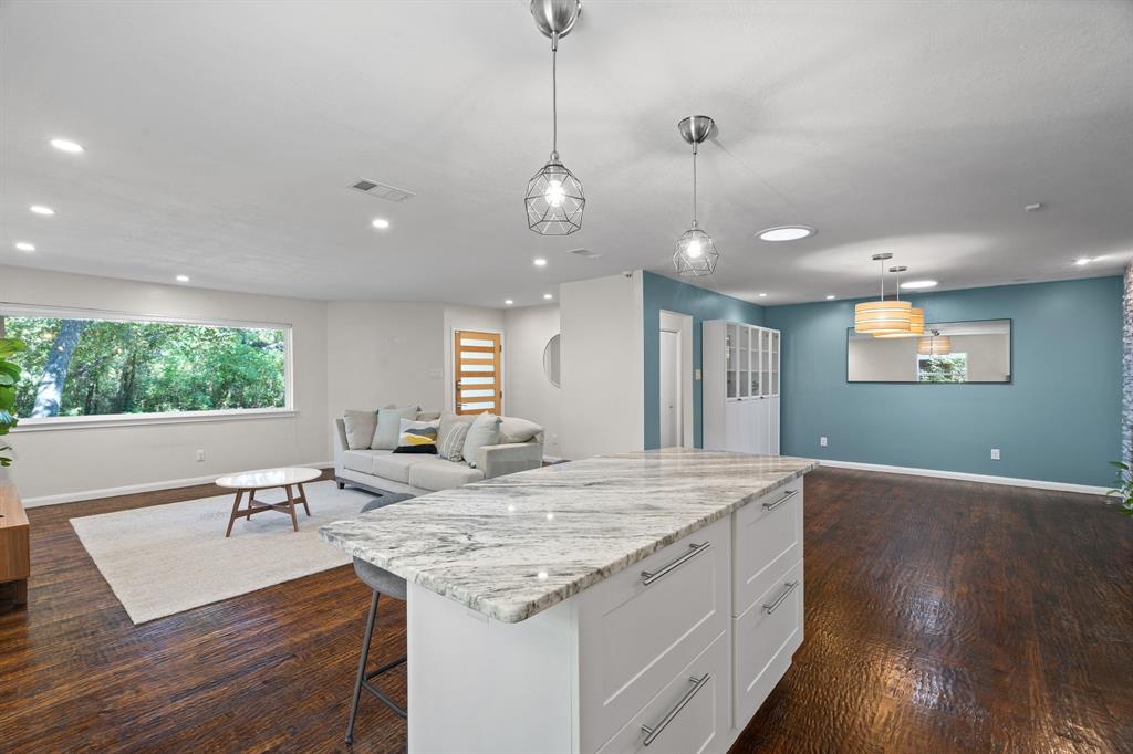 Tucked away in coveted Lochwood neighborhood, this exquisite 3-bedroom, 2-bath home offers the perfect blend of modern updates and tranquil living. New HVAC in 2022. Just minutes from Downtown Dallas and the scenic White Rock Lake, you'll enjoy the best of both worlds — city convenience with the peace and privacy of a nature-rich setting. Nestled among mature trees and backing to a lush greenbelt, this home feels like a true retreat. Step inside to find spacious, light-filled interiors featuring gleaming hardwood floors throughout. The thoughtfully updated kitchen is a chef’s dream, boasting new granite countertops, a large island with gas cooktop and oven, pristine white cabinetry, and a decorative tile backsplash. The open-concept layout flows effortlessly into a generous dining area that could easily double as a secondary living room. Anchored by a striking floor-to-ceiling stone fireplace, it's a warm and welcoming space ideal for entertaining or relaxing. The expansive primary suite is your personal sanctuary, complete with a fully renovated spa-like bathroom, an oversized walk-in shower, and a custom walk-in closet offering both style and functionality. Two additional guest bedrooms feature hardwood floors and share a beautifully updated bathroom with dual sinks, floating vanity, and chic circular mirrors. Step outside to enjoy a large, beautifully maintained backyard and a covered patio — perfect for morning coffee or evening gatherings. Whether you're unwinding at home or heading out for a lakeside jog, this home offers a rare connection to nature without sacrificing location. Don't miss your opportunity to own a piece of paradise in Lochwood — schedule your tour today! HAVE YOUR AGENT SEND YOU THE PROPERTY VIDEO IN THE VIRTUAL TOUR LINKS.