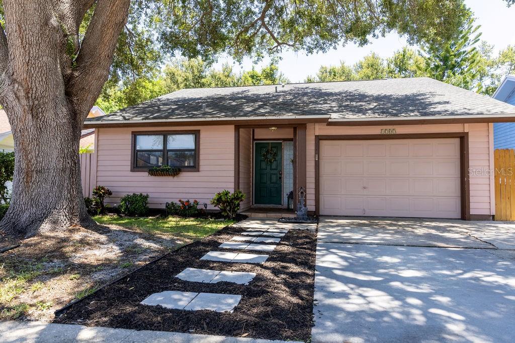 Beautifully maintained 3-bedroom, 2-bath single-family home in an exceptionally convenient location. A commuter's dream, offering easy access to everything the Tampa Bay area has to offer—approximately 20 minutes to the Gulf beaches, 24 minutes to Tampa International Airport and downtown St. Petersburg, and 26 minutes to Clearwater Beach. Inside, you'll find soaring vaulted ceilings, hardwood flooring, and updated bathrooms. The spacious primary suite features a large walk-in closet and private ensuite bath. Major updates include a roof replaced in July 2020 with peel-and-stick underlayment and architectural 3-dimensional shingles, as well as a newer water heater. The side yard has been enhanced with low-maintenance turf, providing year-round curb appeal and usability.