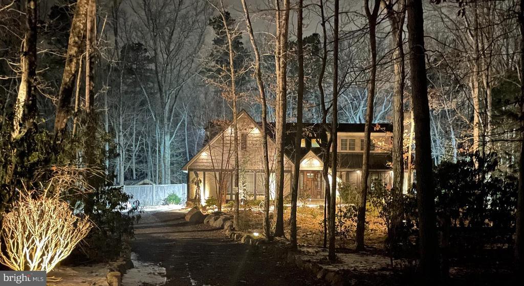 3/4 bedroom, 2.5 bath English-styled cottage nestled on over 3+ acres of wooded privacy in Medford Township! With its cedar shake siding and brick accents, this is truly a one-of-a-kind home. Pull up to the circular driveway and enter through the sun-filled two-story foyer, featuring hardwood floors throughout, with heated floors in the sunroom and primary bath. Enjoy peace of mind with a new metal roof (2018) and a stunning David Ramsay kitchen complete with commercial-grade appliances, a farmhouse sink, custom-made snack bar, and a soapstone island. You’ll love the abundance of Andersen windows, allowing natural light to pour in. The living room offers a beautiful brick fireplace, plus a family room with charming beam ceilings. Upstairs, you’ll find three spacious bedrooms and a former fourth bedroom that has been transformed into a custom dressing room/closet. The luxury primary suite feels like a Vail, Colorado retreat, featuring a spa-like bath and vaulted beam ceilings. That’s not all, the oversized garage, currently used as a music studio, offers incredible flexibility and can easily be converted back to a garage with the door intact. The garage connects to a full basement, providing fantastic space for storage, a wine cellar, or whatever suits your needs. Additional features include a custom fence surrounding the property, generator, gazebo with hot tub, tankless hot water system, new HVAC (2016), and over $100,000 in landscaping.  This home is a happy space giving nature a run for they money!