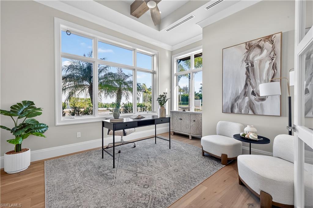 Home office with light wood-type flooring and ceiling fan