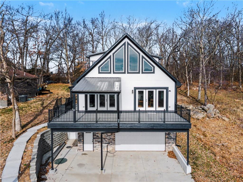 Lake life is calling—and this one delivers the views, the space, and the fun! This stunning three-story home offers 3 bedrooms, 3 full baths, 1 half bath, a 2-car garage, and approximately 3,700 square feet of beautifully designed living space, all set against breathtaking lake views.From the moment you walk in, you’ll be wowed by the soaring ceilings, open-concept layout, and walls of windows that flood the home with natural light and showcase the water from nearly every angle. The kitchen is made for entertaining, featuring granite countertops, an oversized island, and a walk-in pantry, all flowing seamlessly into the expansive dining and living areas—perfect for hosting family and friends after a day on the lake.The main level also offers exceptional convenience with a laundry room, half bath, two additional bedrooms, and a full bath. Upstairs, the private primary suite feels like a true retreat, offering even more spectacular lake views along with a spa-like bath complete with double vanities, a soaking tub, walk-in shower, and two generous walk-in closets. An additional laundry area in the primary suite adds even more comfort and ease.The massive lower level is ready for lake-day fun, with plenty of extra living space, a wet bar, and a full bath—ideal for entertaining, relaxing, or rinsing off after a day on the water.Located in beautiful Lake Lotawana, this home gives you access to all the charm, recreation, and lifestyle the lake is known for. Best of all, it’s positioned on the second tier, giving you the incredible views of first-tier living at a much more attractive price. This is your chance to enjoy the lake lifestyle in a home that truly has it all.