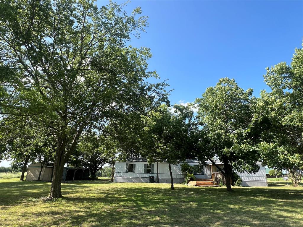 A graveled county road takes you away from the hustle and bustle to your own ranchette on 2.91 acres.  You’ll have plenty of open area for gardening and or livestock.  Mature oak and pecan tress surround the immaculate 3 bedroom, 2 bath mobile home that is move-in ready. The home includes a new roof in 2024, a breakfast bar, new stainless steel appliances in kitchen, dining area with patio doors to back deck, 2-car carport, and a front porch.  Access is also available from the adjacent private road.  Country living but still close to city convenience between Greenville and Sulphur Springs!  Texas A & M Commerce is 10 minutes away and downtown Dallas is just over an hour away.
