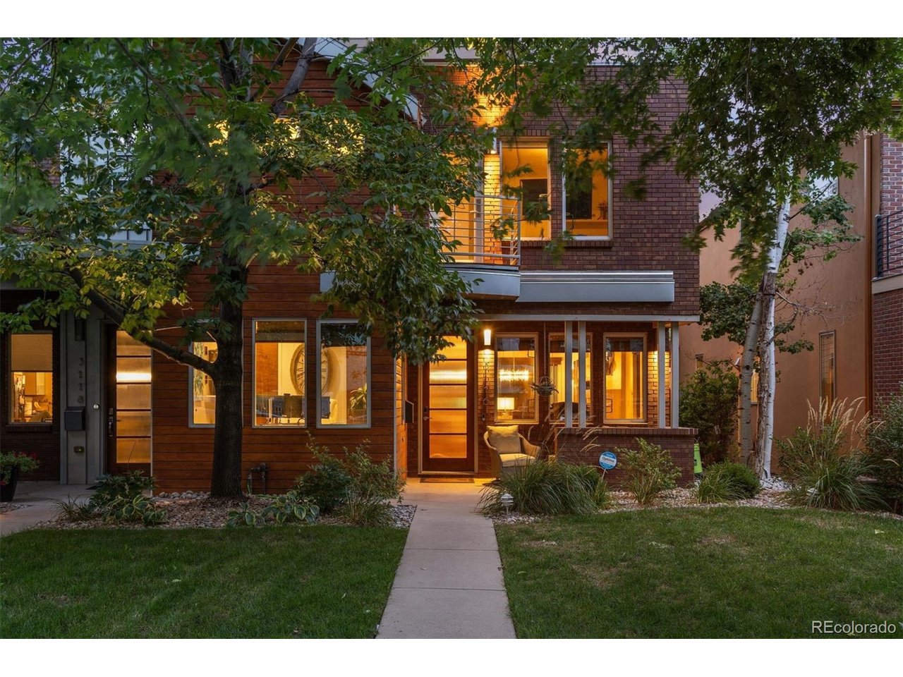 This standout residence in the heart of the Highlands is a dream for gathering, entertaining, & relaxation. Purposefully built with two-thirds of the frontage dedicated to this unit, it is incredibly expansive for a duplex, offering the livability of a detached single-family home. Soaring 20-ft ceilings & a floating open-tread staircase welcome you into the sun-drenched main level. The kitchen features high-end panel-ready appliances, a built-in wine refrigerator & walk-in pantry with custom shelving & storage. Architectural details connect the main level to the outdoors, with an accordion pass-through window in the kitchen and full-height accordion doors in the dining room opening directly to the patio. The outdoor living space features a custom pergola, built-in grill & smoker, & brick fireplace for year-round entertaining. Generous windows & abundant natural light make the main-level bedroom equally suited as an office. Upstairs, the generous primary suite is a private retreat with custom-designed storage by Closet Factory. A double-sided fireplace connects the bedroom & 5-piece bath, thoughtfully designed with tile detailing & a walk-in shower with built-in bench. An additional bedroom suite features an ensuite bath & private balcony, while a spacious laundry room provides additional storage. The penthouse level offers endless opportunities for hosting, with a built-in bar in the living area & rooftop terrace featuring a fire pit. The finished basement adds exceptional versatility with a large media room, projector & screen, full wet bar, spacious wine cellar, guest bedroom & full bath. A rare 2-car garage offers additional height for storage, plus a 3rd parking space adjacent to the garage. Just blocks away, Highland Square offers favorite restaurants, coffee shops & local boutiques along 32nd Ave. Originally designed as the developer's residence, this unit delivers a rare combination of space, flexibility & location in the treasured Highlands neighborhood.