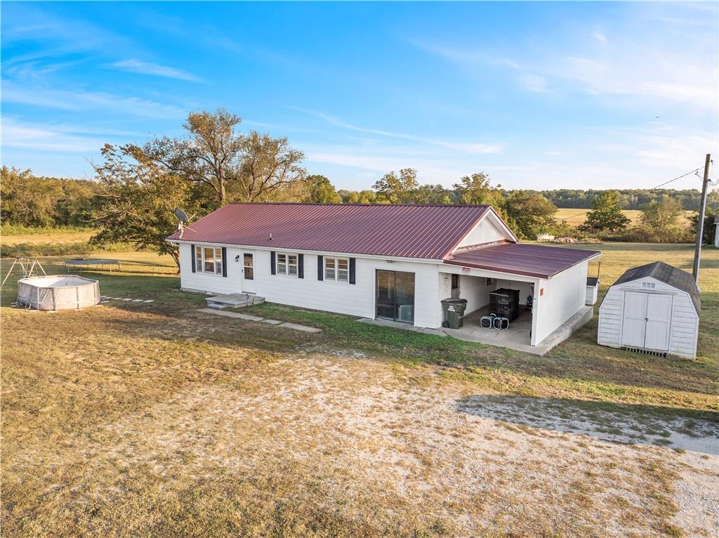 Looking for a little more space without giving up convenience?! This 2-bedroom, 1-bathroom home offers 1,300 square feet of living space on 2.61 surveyed acres just outside the city limits of Nevada, Missouri, in the Nevada School District. Positioned just off 54 Highway, the property provides easy access to both Nevada, MO and Fort Scott, KS, making it an ideal location for those who value both space and accessibility.

Inside, you’ll find original hardwood floors flowing through the main living area and bedrooms, creating a warm and inviting feel. The refrigerator and range stay with the home, making move-in simple. A converted garage adds additional living space — perfect for a second living room, home office, or the potential to transform into a third bedroom to fit your needs.

Outside, enjoy the detached shed for storage, attached carport for covered parking, and a new metal roof for added value and peace of mind.

While a portion of the acreage lies within a mapped floodplain, the home itself is not located in a floodplain, offering peace of mind and usable open space.

With its combination of versatile layout, convenient location, and open land, this property presents an excellent opportunity for a starter home or investment.

**Showings begin Monday October 20, 2025**
Please note that overnight notice is required — be sure to call in advance to schedule your showing!