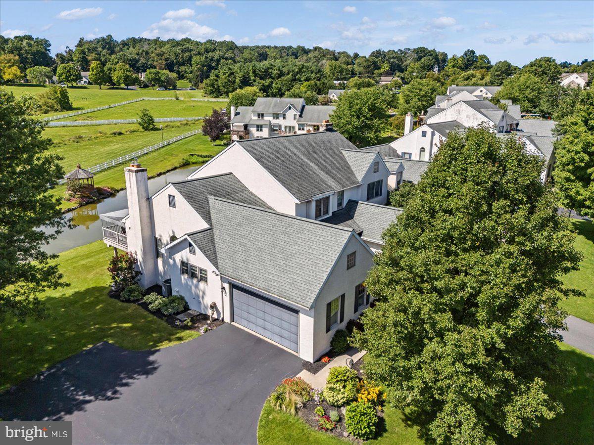 This exquisite end-of-row townhouse, located in the desirable Summerfield at Elverson, offers a blend of modern convenience and classic Colonial charm. Spanning 2,750 total square feet, the residence features four spacious bedrooms and three and a half bathrooms, including a primary suite with a luxurious walk-in closet and a well-appointed bathroom. The interior boasts elegant finishes such as solid hardwood and ceramic tile flooring, complemented by built-ins and chair railings that enhance its character. The kitchen is equipped with stainless steel appliances, including a built-in microwave and dishwasher, and offers an inviting eat-in area. Enjoy cozy evenings by one of the two fireplaces or entertain in the combination dining/living space. The partially finished basement provides additional versatility. Residents benefit from community amenities, including lawn care and snow removal services. The neighborhood is well-served by convenient walking trails and a beautiful pond with a gazebo that completes the view off the awning-covered back deck.