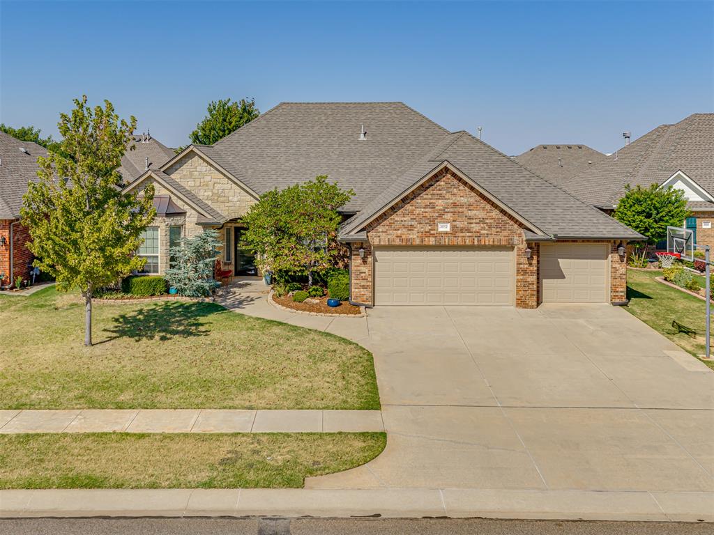 Set back behind mature trees on a shaded lot in Highland Village, this French Country style home pairs a split three-bedroom plan with a private study and a large bonus room upstairs - flexible enough to serve as a fourth bedroom, playroom, or media room. Past the arched entry and its transom window, French doors open to the study, where a bay of windows lights a full wall of built-in bookshelves. The main living area centers on a gas fireplace framed in granite and dark millwork, with three tall windows and a clear line of sight to the kitchen. White raised-panel cabinetry, granite counters, a tumbled-stone backsplash, 5-burner gas cooktop, double KitchenAid ovens, and under-cabinet lighting anchor the kitchen, with a breakfast area on one side and a separate formal dining room on the other by the entry. The primary suite sits apart from the secondary bedrooms under a tray ceiling; its bath has two separate vanities, a slate-tiled floor, corner tub, a walk-in shower, and a walk-in closet. Two secondary bedrooms share a granite-topped hall bath, and a half bath serves guests. Granite continues throughout, including the utility room with its own sink, cabinetry, hanging rack, and mud bench, which is perfect for every day storage. Crown molding and tile run through the main living spaces. Upstairs, the bonus room adds built-in shelving, a window seat with storage cubbies, and a built-in desk. Out back, a large covered patio with ceiling fan and TV mount that opens to a fenced yard with a mature shade tree, planting beds, and a storage shed. The 3-car garage also has an in-ground storm shelter, the roof shingles are Class 4 impact-resistant, which can save you tremendously on your insurance premium.  Neighborhood amenities include the pool, clubhouse, playgrounds, soccer field, basketball court, and walking trails around the ponds, and 7 minutes to the University of Oklahoma, I-35, 5 minutes to I-35 and the University North Park shopping center.