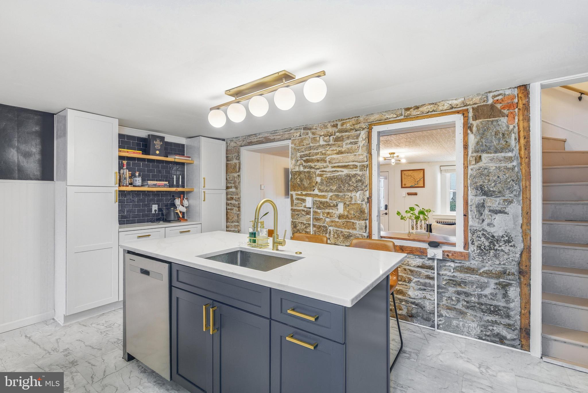 Welcome to 116 South Street in the sought after Phoenixville Boro in the Phoenixville Area School District.  This townhome has a large covered front porch for drinking your morning coffee or people watching.  Upon entering the home you'll see the living room with original hardwood flooring and a brand-new window.  This first floor has a fantastic flow throughout. The living room peeks right into the kitchen that has been fully renovated with newer stainless-steel appliances. The oversized kitchen island with quartz countertop is perfect for entertaining.  Notice the exposed stone wall with original wood trim.  This house provides new designs while leaving some of the old-world appeal. The coffee bar not only adds even more counter space but extra cabinets as well, providing plenty of storage. As you continue to move through the house you'll see the renovated powder room on the main floor. The included washer and dryer sit in a sizable laundry room off of the kitchen with built in drying racks and an abundance of natural light.  The fenced in backyard is accessible through the laundry room with a large surface area for outdoor furniture, a grill and more.  On the second floor you'll find 3 bedrooms with LVP flooring.  One is currently being used as an office. A full bathroom resides on this floor with a tub/shower combo and vanity for storage. Head up to the third floor to find a spacious 4th bedroom with a large closet and 2 new windows that capture more of that sunlight.  Unlike many other homes in the Boro, this one comes with a full-length basement that you can actually stand up in and is perfect for storage.  You can access the basement through the first floor powder room. Not shown in pictures is the recently installed and upgraded 200-amp electrical panel. This home is located a quick walk away from local parks and near the Bridge Street restaurant row.  Whether you're purchasing this home for yourself or you're looking to buy an investment property to rent out, you have to come see it for yourself.  The kitchen is even more beautiful in person!