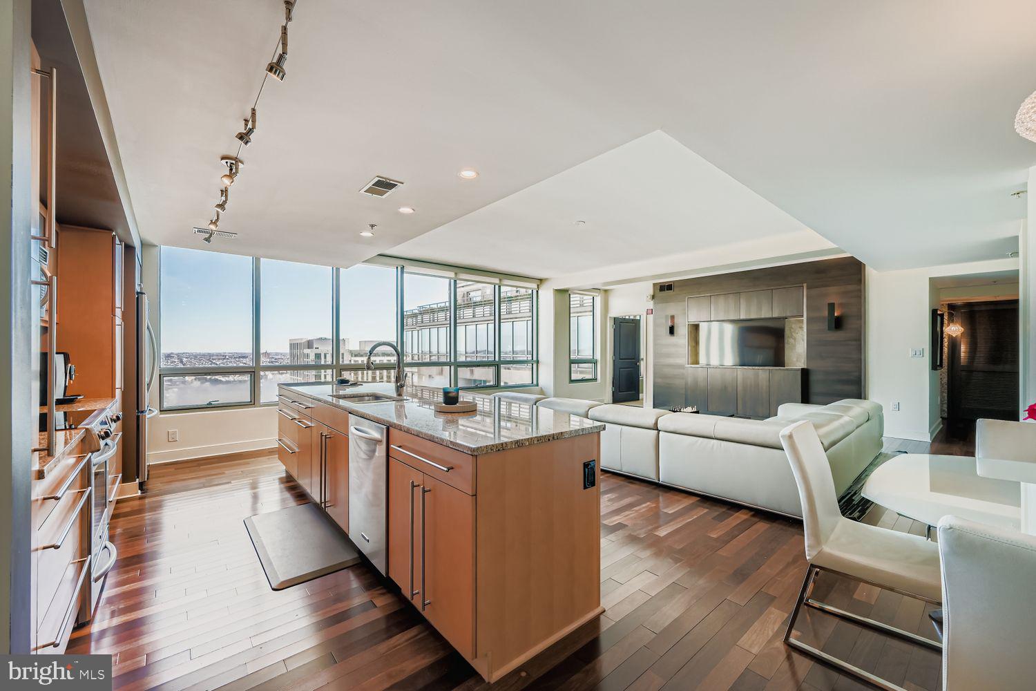 This stunning 3-bedroom, 3-bath high-rise residence offers approximately 1,900 square feet of thoughtfully designed living space, positioned 27 stories above the city. Expansive floor-to-ceiling windows fill the home with natural light while showcasing sweeping open-sky and city views.The open-concept floor plan seamlessly connects the kitchen, living, and dining areas, creating a sophisticated yet comfortable space ideal for everyday living and entertaining. The chef’s kitchen features a large center island and is complemented by upscale finishes throughout, including rich hardwood flooring, designer lighting, custom closets, upgraded window treatments, and modern interior details.The corner primary suite is a private retreat, highlighted by double exposures, floor-to-ceiling windows, a spacious walk-in closet, and a spa-inspired bathroom with double vanity, separate shower, and deep soaking tub. Custom electric blackout shades have been installed in the primary bedroom, with custom electric shades also added to the living area for enhanced privacy and light control. Two additional generously sized bedrooms offer flexibility for guests, office space, or additional living needs. Experience elevated luxury living at The Vue, located in the heart of Harbor East. Two assigned parking spaces and private storage are included, along with covered parking and 24-hour garage security for peace of mind. Residents of The Vue enjoy full-service amenities including concierge and 24-hour security, with condo fees covering heat, air conditioning, and water. The building offers direct access to the Coppermine gym, featuring indoor heated pools and squash courts, as well as the on-site Harbor East movie theater. Owner occupied till June.