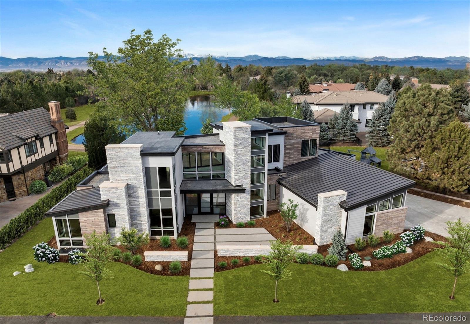 This rare brand-new construction showcases Modern Colorado architecture with refined Mid-Century touches, designed by the renowned Woodley Architecture. Located in one of the most coveted enclaves, Buell Mansion, this home is perfectly positioned on Sandy Lake Road, offering breathtaking mountain & lake views. A dramatic two-story entry with floor-to-ceiling Marvin windows and expansive sliding glass doors create a stunning first impression. High-end finishes abound including custom wide-plank engineered flooring, a mono-stringer staircase with glass side panels, and electronic privacy film at the front door for enhanced security. The home features a stunning chef’s kitchen that faces a set of stacking doors that blur the lines between indoor and outdoor living. The kitchen is highlighted by floor-to-ceiling sleek walnut-hued cabinetry, top-of-the-line quartz countertops and backsplash, brushed gold designer plumbing, Thermador & Wolf appliances, a hidden walk-in pantry, island seating, and a spacious mudroom off the 4-car garage complete the space.A dining room with custom sliding doors allows for seamless indoor-outdoor entertaining, while the great room—adjacent to both the kitchen and dining areas—features a linear fireplace.With 6 bedrooms and 8 bathrooms, the layout includes a luxurious main-floor primary suite with dual closets, an elegant spa-inspired bath with heated floors, and a sculpted soaking tub.The upper level offers a media space with a private patio and two ensuite bedrooms. The lower level features a custom bar, two additional ensuite bedrooms, space for a home gym, and an area designed & pre-wired for a future golf simulator or home theatre. Buell Mansion is a gated community with manned security, tennis courts, a swimming pool, and a historic mansion available for private events. Also, located within the renowned Cherry Creek School District, including CHVE, with convenient school bus service.