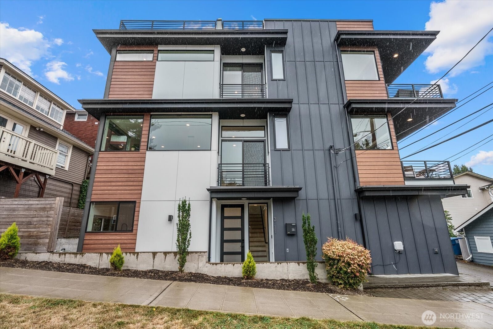 Bold design, sweeping views and an incredible Queen Anne location make this remarkable home truly unforgettable. Created by award winning Stephenson Design Collective and refreshed with new interior paint, the residence blends modern architecture, abundant natural light and effortless indoor and outdoor living. The lower level welcomes you from the attached two car garage and features two comfortable bedrooms with access to private outdoor space. Upstairs, the heart of the home is ready for memorable gatherings with an oversized kitchen island, walk in pantry, powder bath and two inviting balconies. The private upper level is dedicated to a luxurious primary retreat with a generous bedroom, its own balcony and a spa inspired five piece bath. An expansive rooftop deck completes the experience with panoramic views in every direction. Step outside and enjoy neighborhood cafés, restaurants, parks and everyday conveniences, plus easy access to Fremont, Ballard, South Lake Union and downtown Seattle. Sophisticated, comfortable and perfectly connected, this is Queen Anne living at its finest. Learn more about the designer at https://www.stephensoncollective.com/