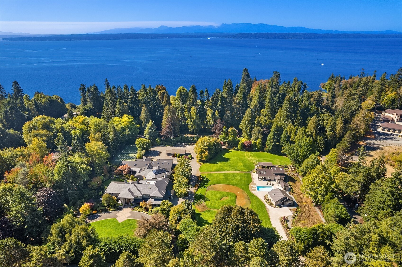 Embassy-style estate nestled in Woodway on shy 4-acres. Skyward 2-story windows, Artisan chandelier & intricate millwork highlight interiors framed by coffered ceilings, Corinthian columns, custom ironwork & sweeping travertine staircase. Multiple French doors open to lush grounds w/ pool, outdoor fireplaces, Little League reg. baseball field, tennis ct, apiary & cottage coop. Rainforest spa w/ hot tub & sauna. Main-flr Primary Wing boasts fireplace, dual walk-ins, spa-like 5-pc bth & W&D. 4 full kitchens, butler’s pantry. Grand dining rm. Wood-paneled den. Library could be 7th bed. 2 ADUs + guest suite. 3 garages house 14 cars. Theater & Grotto. Entertaining Suite leads to architectural indoor basketball ct. Unmatched amenities & artistry.