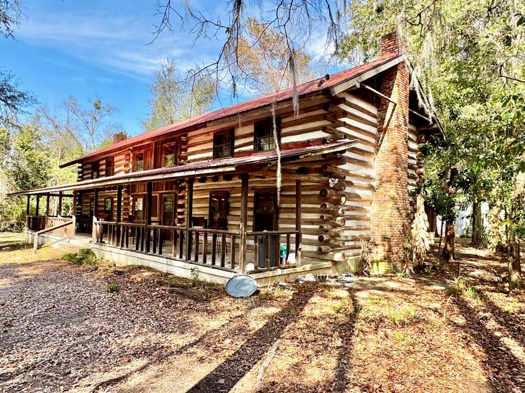 Your piece of Lake Seminole is waiting for you.  ( Currently Airbnb property rent rolls available) Discover your expansive 5-bedroom, 3.5-bath log cabin nestled on over two acres of prime Lake Seminole property. This charming retreat, affectionately dubbed "The House that Jack Built," has a rich history; it was constructed by the local legend and Bass Hall of Fame member Jack Wingate in 1978, using juniper logs sourced from Telogia Creek.   Boasting over 4,100 square feet of living space, the cabin features three stunning fireplaces, an open-concept kitchen, generously sized bedrooms, cozy loft areas, and a wet bar perfect for entertaining guests. The property offers ample privacy, beautiful natural surroundings, and extensive access to the water, making it an ideal choice for both a primary residence and a vacation getaway.   With the main cabin accommodating 18+ guests comfortably, enjoy the convenience of a small apartment situated above a fully equipped workshop just behind the home. Seize the opportunity to make this historic log cabin your own!