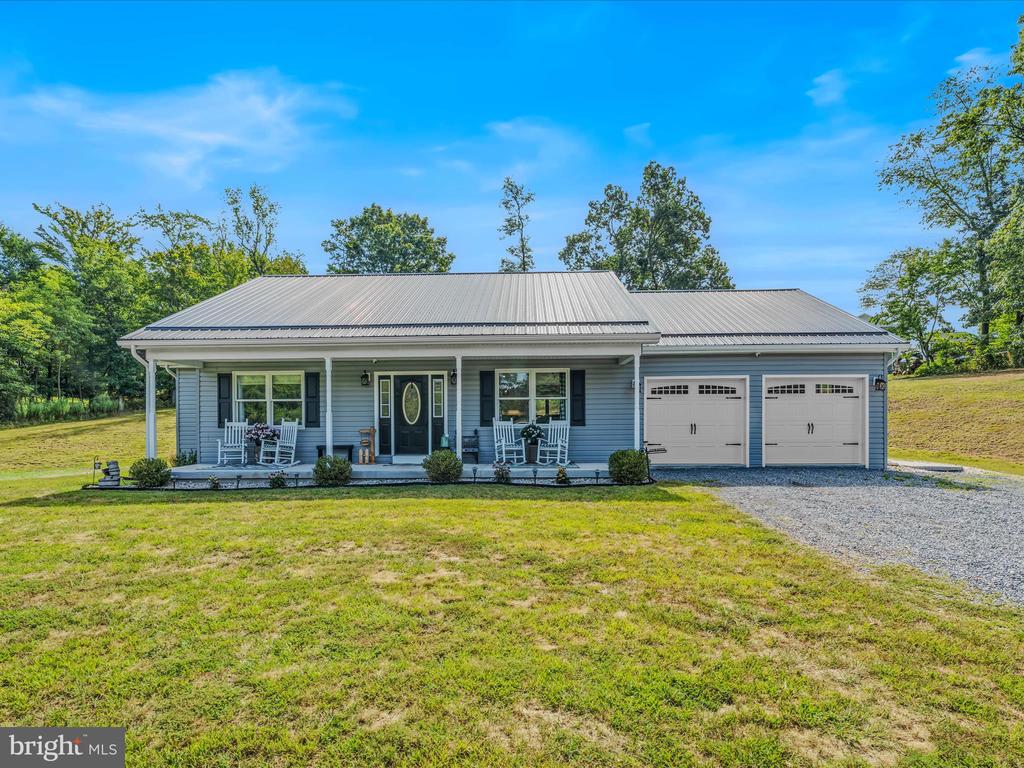 Maintenance-Free Rancher! This 2100 square foot residence boasts a spacious open kitchen equipped with granite countertop, center island and stainless steel appliances, a dining room with glass doors that lead out to an expansive patio ideal for large family gatherings, and a living room. The property also features three bedrooms, including a generously sized primary bedroom with an attached bath, complete with a soaking tub and large two-person shower. Additional features include a full hall bath, luxury vinyl plank flooring throughout, an unfinished basement, 2 car garage, covered front porch, public water, public sewer and a heat pump. The property is situated on a .994-acre lot, accessible via a paved road, and offers a beautiful setting for this stunning home.