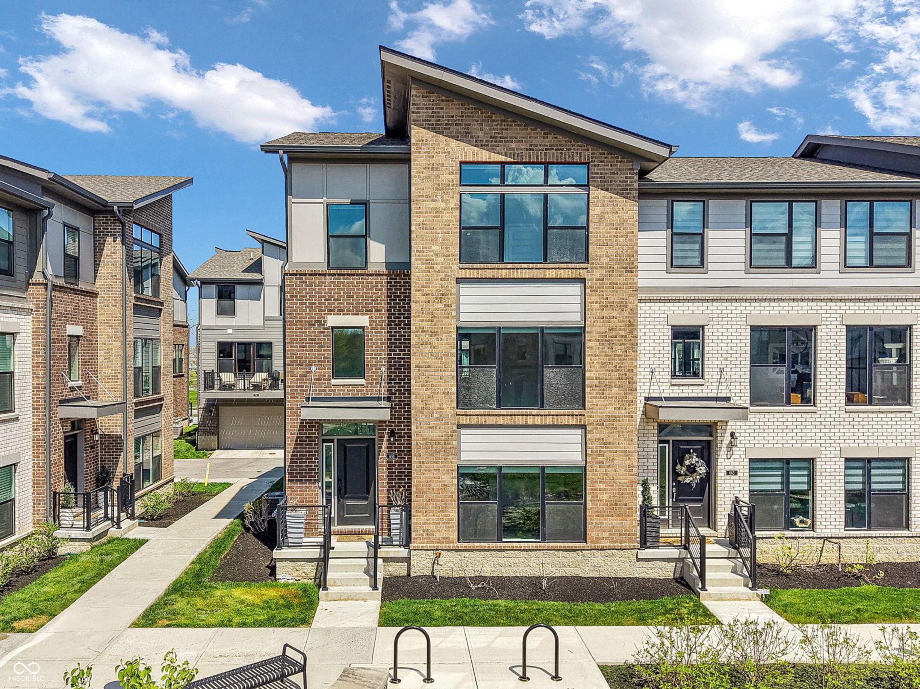 Step inside this stunning tri-level townhome, ideally located just minutes from Downtown Carmel, the Monon Center, and US-31. Built in 2022, this home showcases high-end finishes throughout and offers 3 bedrooms, 4 bathrooms, and a spacious 2-car garage. The lower level is perfect for entertaining, featuring a convenient half bath and kitchenette. On the main level, you'll find a beautifully designed kitchen complete with a gas cooktop, quartz countertops, and an oversized center island, opening to a bright living space with a cozy gas fireplace and room for dining. Just off the stairs, a versatile flex space makes the perfect home office or hobby area. Upstairs hosts all three bedrooms, including a spacious primary suite with a large ensuite bath and walk-in closet. You'll also find a full-size laundry room for added convenience. Enjoy low-maintenance living in a prime location close to shopping, dining, and everyday conveniences.