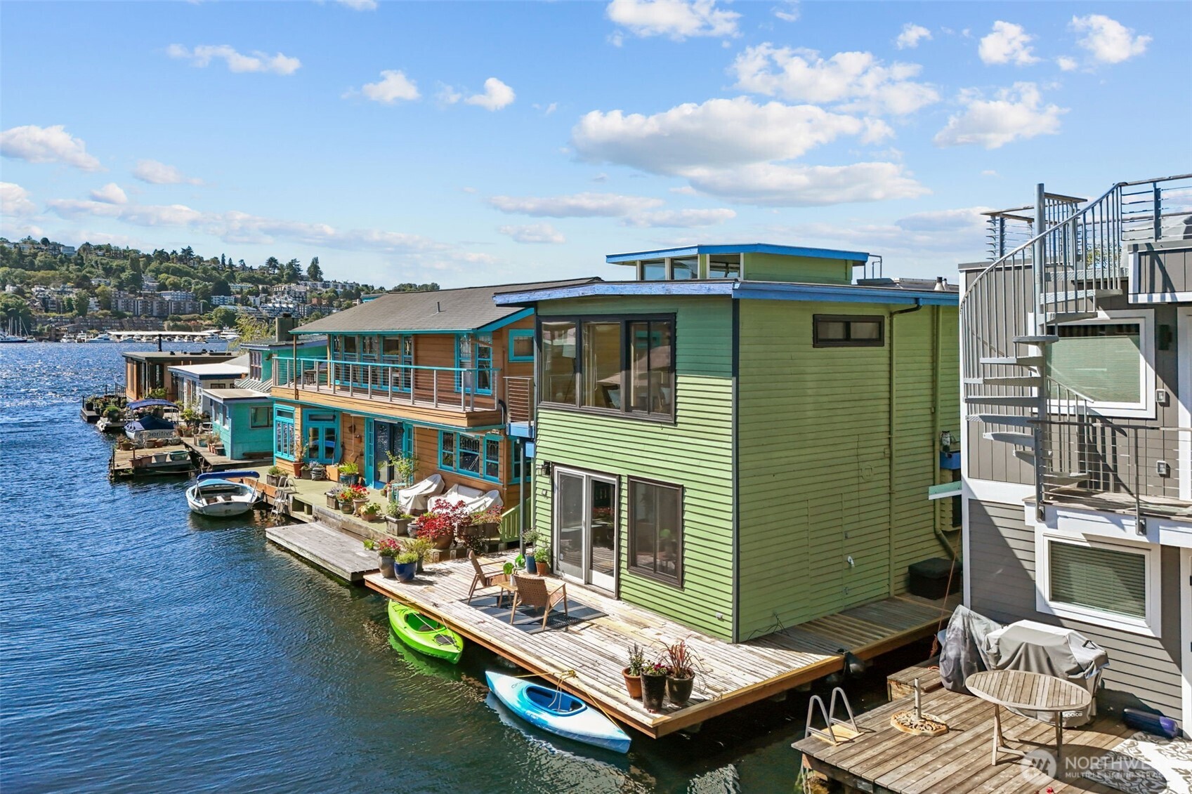 Experience the rare lifestyle of floating home living on Seattle’s coveted Eastlake waterfront. This iconic Lake Union residence includes owned moorage and offers an unmatched connection to the water, skyline, and vibrant boating community. Launch a paddleboard or kayak from your doorstep, enjoy endless days on the lake, and embrace the close-knit neighborhood atmosphere unique to floating homes. Walls of windows frame stunning Lake Union and Seattle skyline views while filling the home with natural light. The versatile upper level lives as a luxurious primary suite, a one-bedroom retreat with living room, or a flexible two-bedroom layout. The fully updated kitchen features stainless steel appliances, granite countertops, rich walnut cabinetry, and under-cabinet lighting. Heated tile flooring, refreshed interior paint, an oversized bath with jetted tub, in-unit washer/dryer, and three separate decks — including a rooftop deck with panoramic 360-degree views — create the ultimate backdrop for lakeside living and unforgettable summer nights.