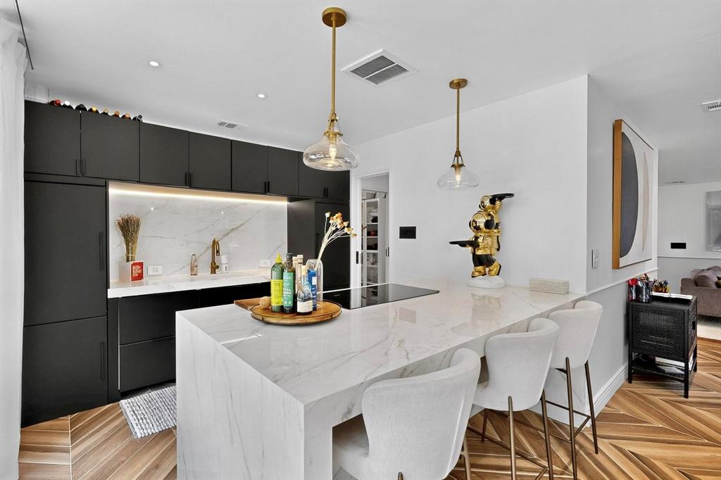 Originally built in 1946 and completely taken down to the studs in 2023, this East Dallas custom rebuild combines historic charm with modern luxury AND includes approved plans for an ADU & additional home expansion! Every inch of this renovated home has been thoughtfully redesigned with quality craftsmanship & high-end finishes. Step inside to an open living & dining area anchored by a chef’s kitchen featuring a Moderno Porcelain waterfall island, soft-close cabinets & premium appliances: DUAL Bertazzoni refrigerators, Miele cooktop + oven, and DUAL Fisher & Paykel dishwashers. Panoramic floor-to-ceiling stackable glass doors flood the kitchen & primary bedroom with abundant natural light, opening seamlessly to the private back patio. Two spa-style bathrooms (converted from 1.5 baths) boast floor-to-ceiling designer tile, brass Delta Vero fixtures, Kohler toilets & upgraded vanities. Additional highlights include a custom walk-in closet system, recessed LED lighting, Legrand Adorne switches + outlets, and a double-sided fireplace enclosure ready for a 2-sided gas unit. Behind the walls, everything is NEW—noise canceling insulation, plumbing, electrical (200 AMP panel) & state-of-the-art Lennox 28 SEER HVAC with smart iComfort thermostat. Other smart home upgrades include AT&T fiber, wireless security system, digital locks, cameras & automatic whole-home exterior night lighting. A fully enclosed & transformed backyard features a paved dining area, pea gravel play yard, oversized storage shed, life-size chess set & gated parking with hexagonal paving grid for multiple cars. Perfectly located across from Tenison Highlands Golf Course, minutes from White Rock Lake, Lakewood Elementary, Santa Fe Trail & Lakewood Village, this home offers both style & convenience. RARE move-in ready opportunity in one of Dallas’ most desirable neighborhoods!