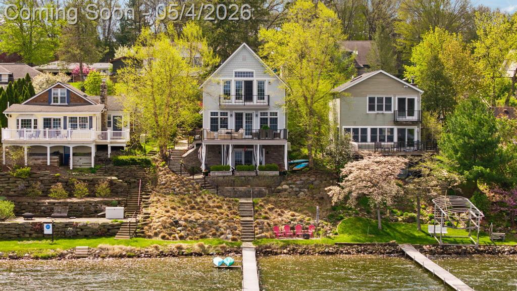 North Lake living at its finest. Designer-owned and featured on HGTV, this 2,400-square-foot cottage is the kind of property that comes along once in a generation: thoughtfully composed, impeccably appointed, and perfectly positioned to capture the magic of lake living. The home unfolds with a quiet sense of drama. A winding path and steps lead through perennial gardens, to a charming entry. At the heart of the home is a gathering space. A generous center island anchors the room, surrounded by custom cabinetry, designer finishes, and warm, layered detail. The dining area is sized to host a holiday table or a relaxed dinner party with ease. The kitchen flows openly into a comfortable living area with a fireplace, flanked by bookshelves.The 3 bedroom 3 bath, 2,400-square-foot floor plan is as functional as it is beautiful. The walkout lower level offers exceptional flexibility. Ideal as a media or sitting room, a home office, a hobby space, or comfortable accommodations for visiting guests -- it is anchored by its own cozy fireplace. Directly outside the lower level are multiple outdoor living areas, including a dedicated gas firepit zone perfect for unwinding after a day on the water, hosting friends late into the evening.Step out onto the expansive deck and the lake takes center stage. Mornings here begin with coffee in hand as the early fishing boats drift across glass-still water in search of largemouth bass, bluegill, and perch. Trumpeter swans glide past in pairs, their reflections doubled on the surface. Sandhill cranes call from the wetlands. The rhythm of the lake becomes part of the rhythm of your day. The view is a living canvas -- culminating each evening in vivid sunsets that reflect across the surface in layers of amber, rose, and gold. The home is designed for full, year-round lake life. Summer days unfold from your private dock -- swimming, waterskiing, paddleboarding, water volleyball, and tubing -- with happy hour aboard the pontoon as the sun lowers, and stars appear in the wide Michigan sky. A