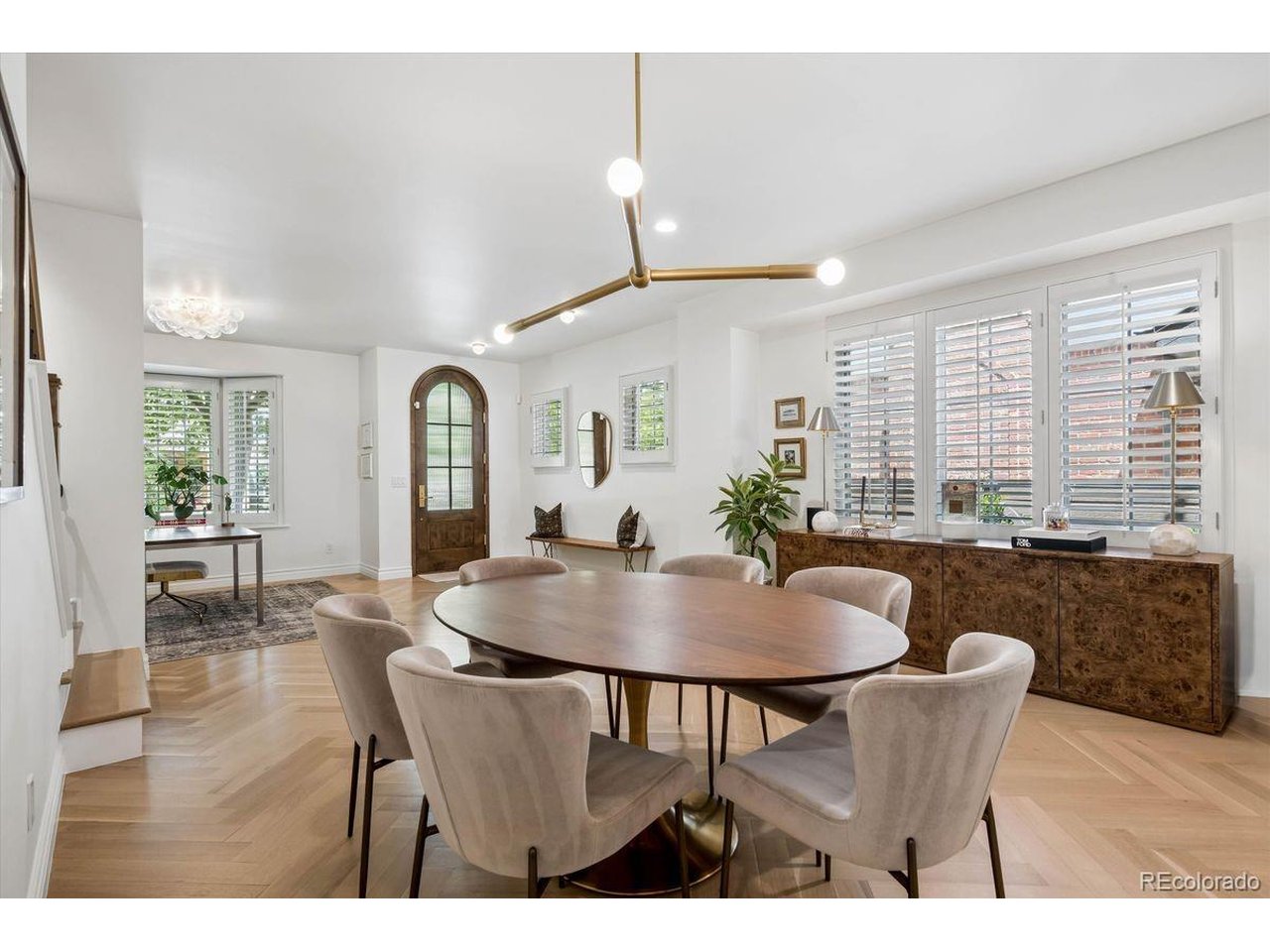 A sophisticated expression of modern luxury, this property has been extensively reimagined with a $500K+ renovation with exceptional craftsmanship, elevated materials, and meticulous attention to detail. The residence features herringbone white oak floors, smooth-finish walls, custom millwork, designer lighting, new eight-foot doors, and beautifully curated hardware throughout. The main level blends warmth and refinement featuring custom built-ins and integrated lighting, and a striking custom bar appointed with marble surfaces, built-in shelving, and brass hardware. The gourmet kitchen boasts white oak cabinetry, marble countertops, Dacor refrigerator, Bosch DW and microwave, and an iconic AGA five-burner gas range. The adjoining family room is anchored by a gas fireplace and offers an inviting space for everyday living. Upstairs, the primary suite is a true retreat, with pitched ceilings, custom cabinetry and an integrated custom bed, nightstands, and sconces. Dual professionally organized closets provide exceptional storage. The spa-inspired five-piece primary bath features marble countertops, soaking tub, and expansive multi-head shower. The second bedroom impresses with Gucci wallpaper, custom blackout draperies, walk-in closet, and private full bath. The fully finished lower level expands the home's versatility with a spacious recreation room and media wall, plus a third bedroom and three-quarter bath. The fourth bedroom is currently configured as a private wellness retreat with walk-in closet, sauna, and treadmill, which are all included. Outside, a private fenced courtyard with dedicated drip system extends the living space. An attached two-car garage and marble-floored mudroom provide exceptional everyday functionality. Within walking distance to all that Cherry Creek has to offer, with nearby parks and tree lined streets, CC Shopping Center, Gates Tennis Center and all of the incomparable boutiques and premier restaurants the area has to offer. Stunning!