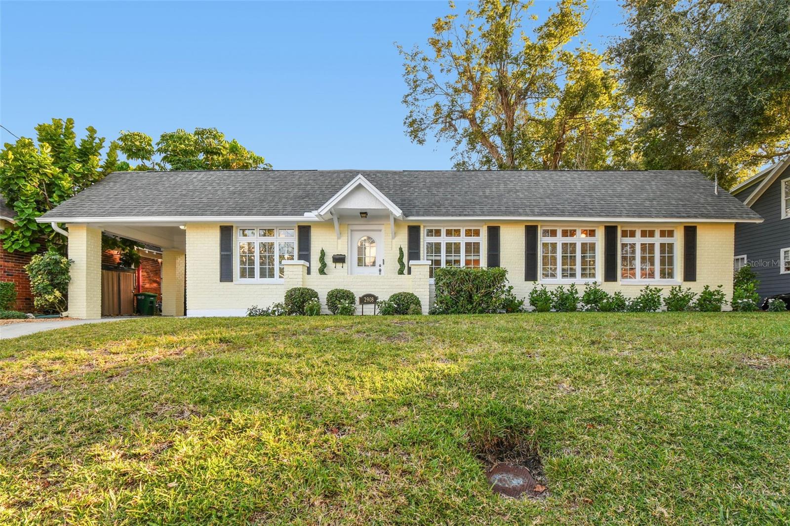 This brick home is located on a lot and ½ (7600 sqft) in the heart of Palma Ceia,  one of South Tampa’s most walkable and cherished communities. From the moment you arrive, this home captures the heart. The living room is filled with natural light from the expansive windows as you enter from the front porch.  A half-wall with wainscoting and elegant columns, creates a transition into the dining room—perfect for hosting intimate dinners or enjoying casual family meals. You can also enter from the porte cochere into the dining room for both convenience and character. The updated kitchen has many features including arched glass-front white cabinetry, a Jenn-Air downdraft gas range a built-in wall oven and microwave, refrigerator, and dishwasher (all new Bosch appliances), a deep double-basin sink, wine rack, and breakfast counter—ideal for morning coffee or entertaining guests. On the opposite side of the home, a spacious flex room features new carpet, dual closets, and French doors that open to the backyard—making it the perfect option for a third bedroom, private office, or media/game room with room to spare. The home’s private quarters are down a hallway that begins just off the dining and living. Here, you will find two additional bedrooms, two full bathrooms, and a well-equipped utility room with upper cabinetry, the hot water heater, and access to the expansive back yard. The primary suite at the rear of the home is a serene retreat, complete with a walk-in closet, two additional closets, and a luxurious ensuite bath with Jacuzzi garden tub, and walk-in shower.
Recent upgrades include fresh interior and exterior paint, stylish new lighting and ceiling fans, updated kitchen hardware, new carpet in the 3rd bedroom, and revitalized landscaping. The fully fenced backyard is a blank canvas ready for your vision—whether it is a sparkling pool, outdoor kitchen, garden retreat, or all the above. The restored oversized knotty-pine (pest resistant) one-car garage at the rear of the lot provides ample storage or workshop potential. Additional features include structural (Piers reinforced June/July 2002 by Wisdom Structural,) and plumbing enhancements over time, an ADT digital security system, and timeless architecture with enduring value.
Set among a picturesque mix of historic homes and luxury new construction, this home embodies the best of South Tampa living—friendly neighbors, tree-lined streets, and strong property values. Walk to neighborhood favorites along MacDill Avenue, or take a short drive to Hyde Park Village, Bayshore Boulevard, Ballast Point Park, or Downtown Tampa. Commuting is a breeze with quick access to I-275, the Selmon Expressway, and Water Street. Families will appreciate the coveted school district, zoned for A-rated Roosevelt Elementary, Coleman Middle, and Plant High School.
Do not miss your opportunity to own a beautifully preserved piece of Tampa history in a location that truly has it all.